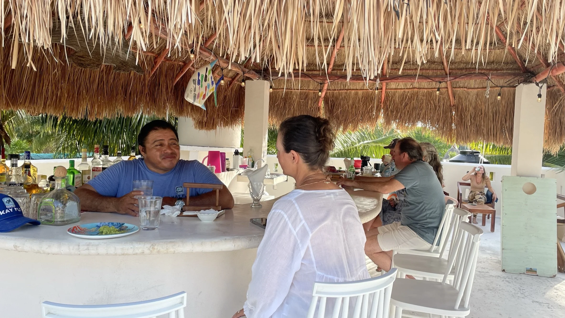 Fly fishing guests relaxing on the rooftop palapa at Kay Fly Lodge in Punta Allen, Mexico after a day of fly fishing on Ascension Bay.