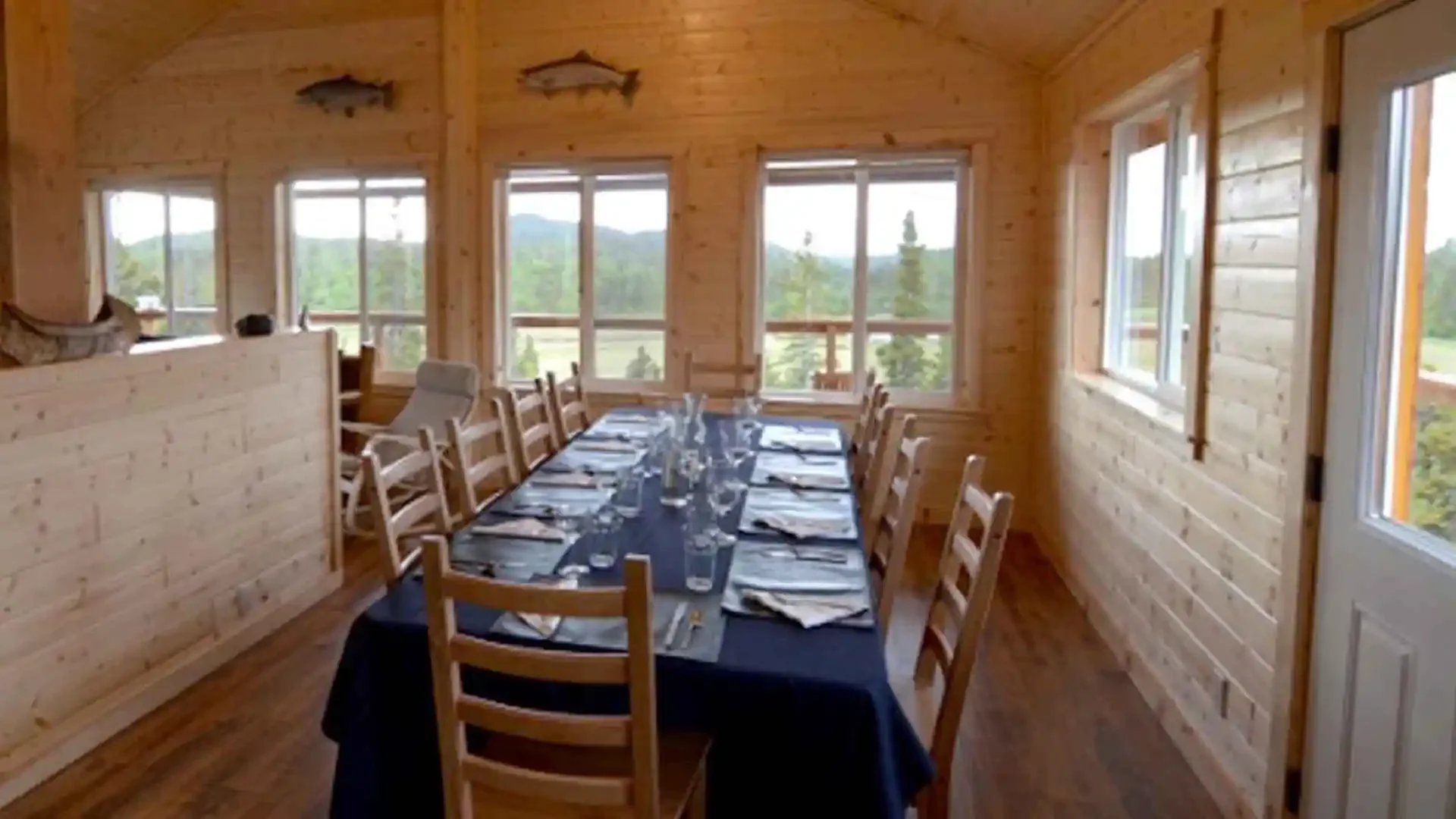 Copper River Lodge dining area long table with chairs and river views Alaska