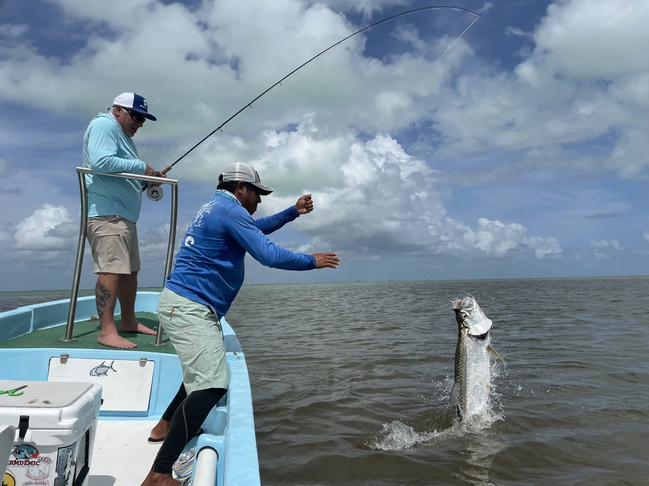 Kay Fly Lodge fishing guide assisting an angler in landing a jumping tarpon in Ascension Bay, Mexico