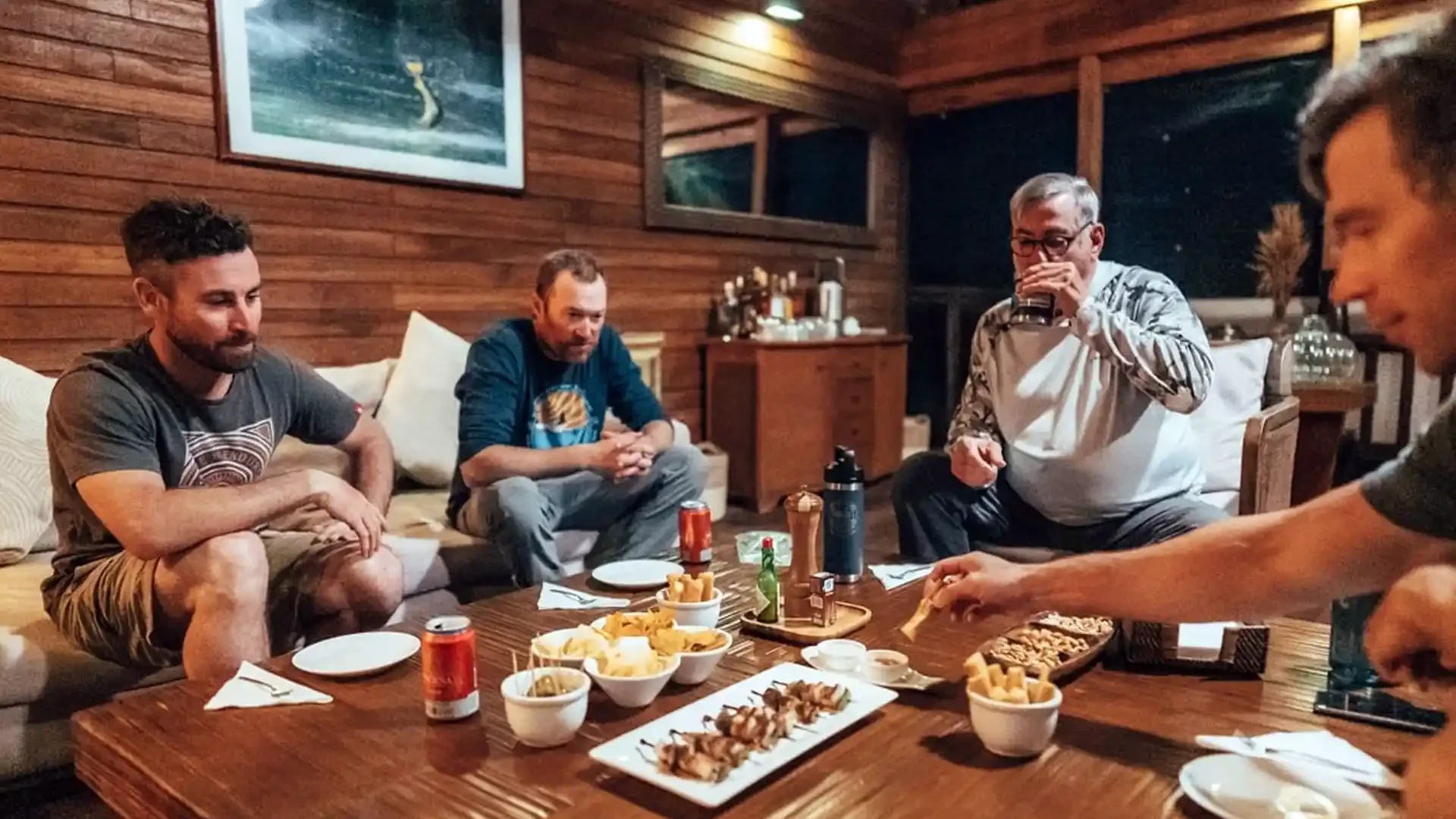 Three anglers seated at a table with white tablecloth enjoying a meal at Tsimane fishing camp in Bolivia