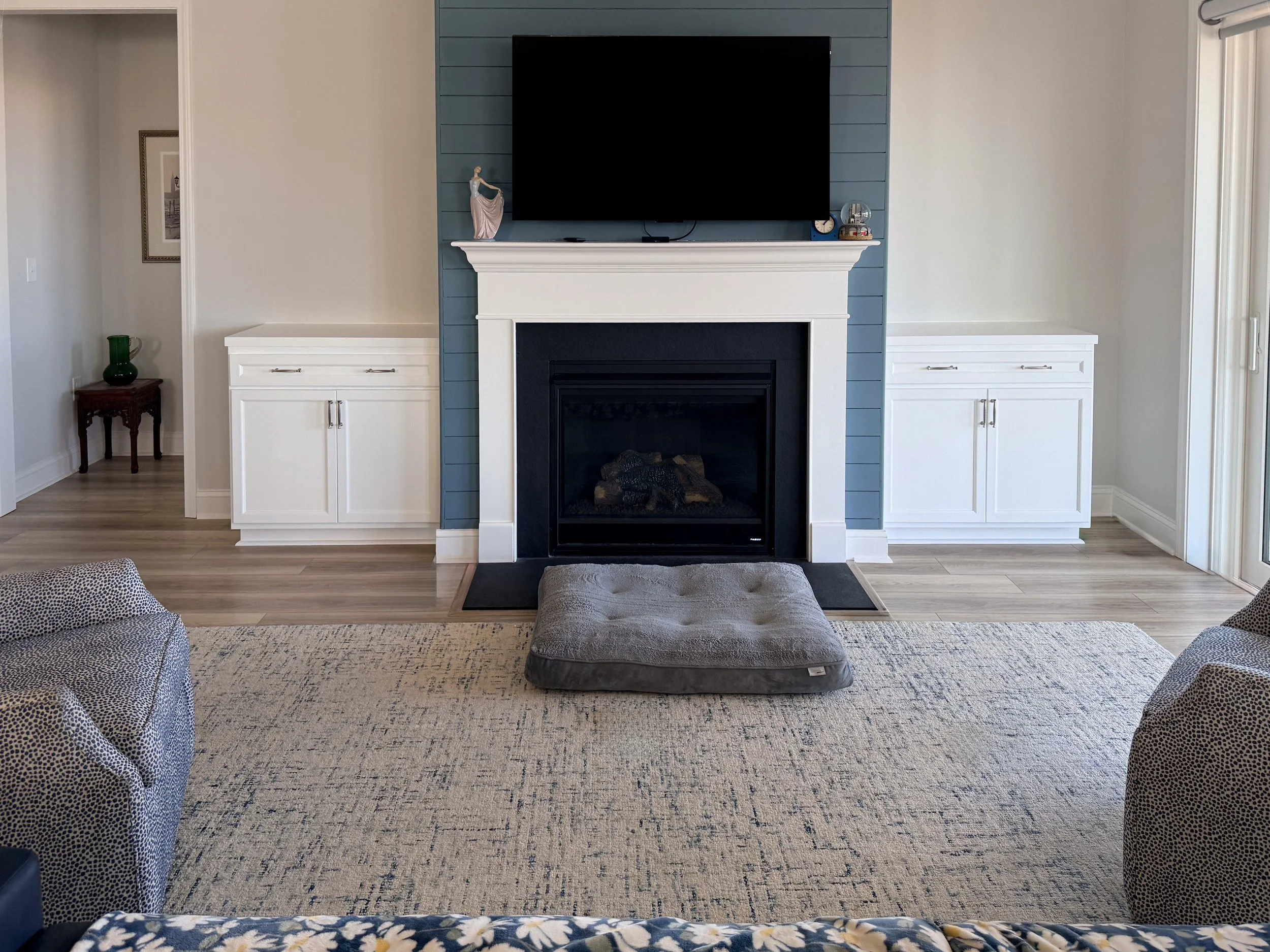Custom built-in entertainment center in Myrtle Beach with white cabinetry, open shelving, and closed storage. Features blue accent shelving and integrated TV niche.