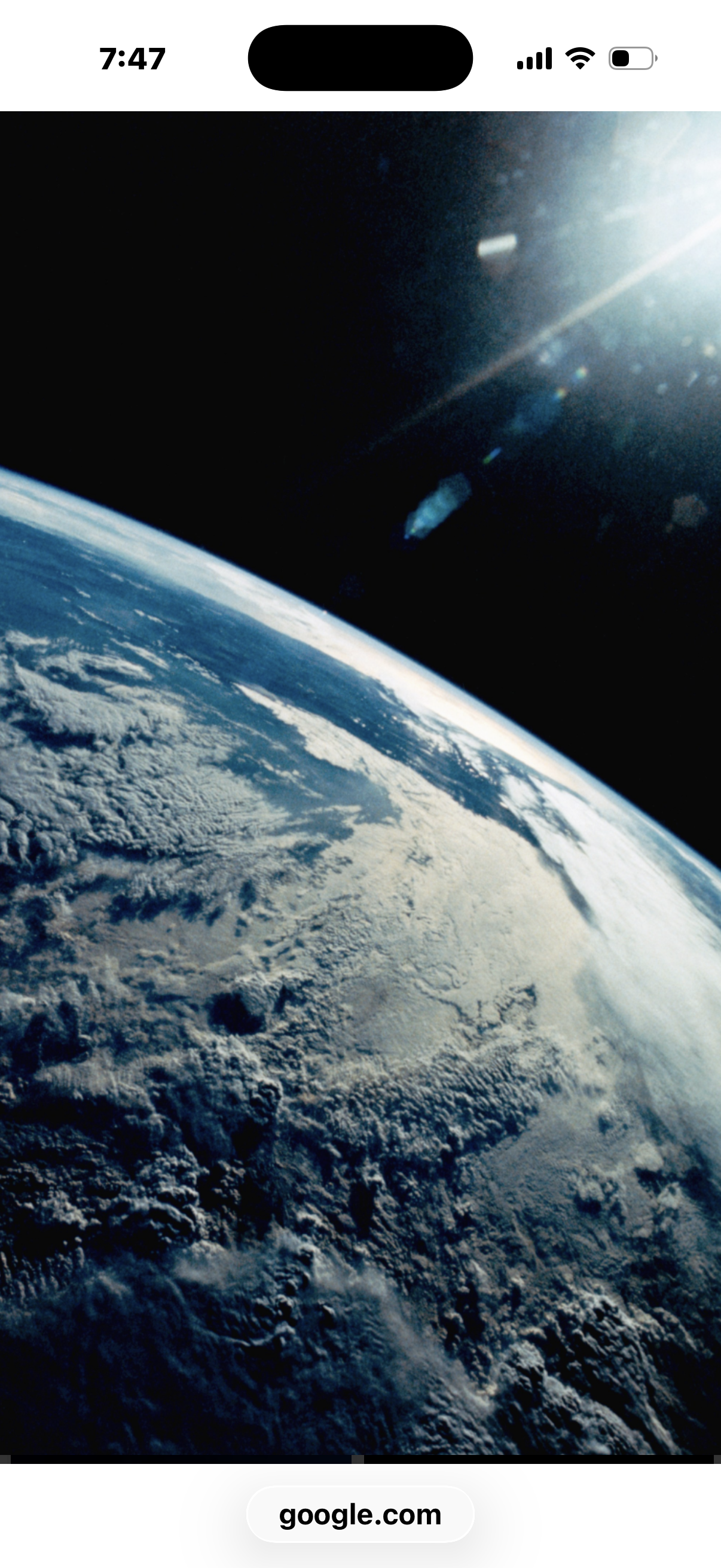 View of Earth from space with clouds and blue oceans, and the Sun shining brightly in the background.