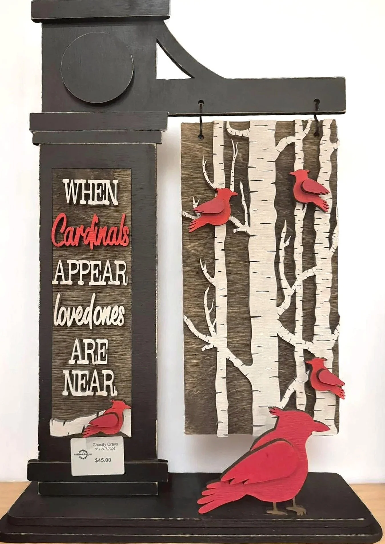 Decorative wooden sign with a quote about cardinals and a birch tree background. Red cardinal figures are attached to the sign and a large cardinal figure is at the base.