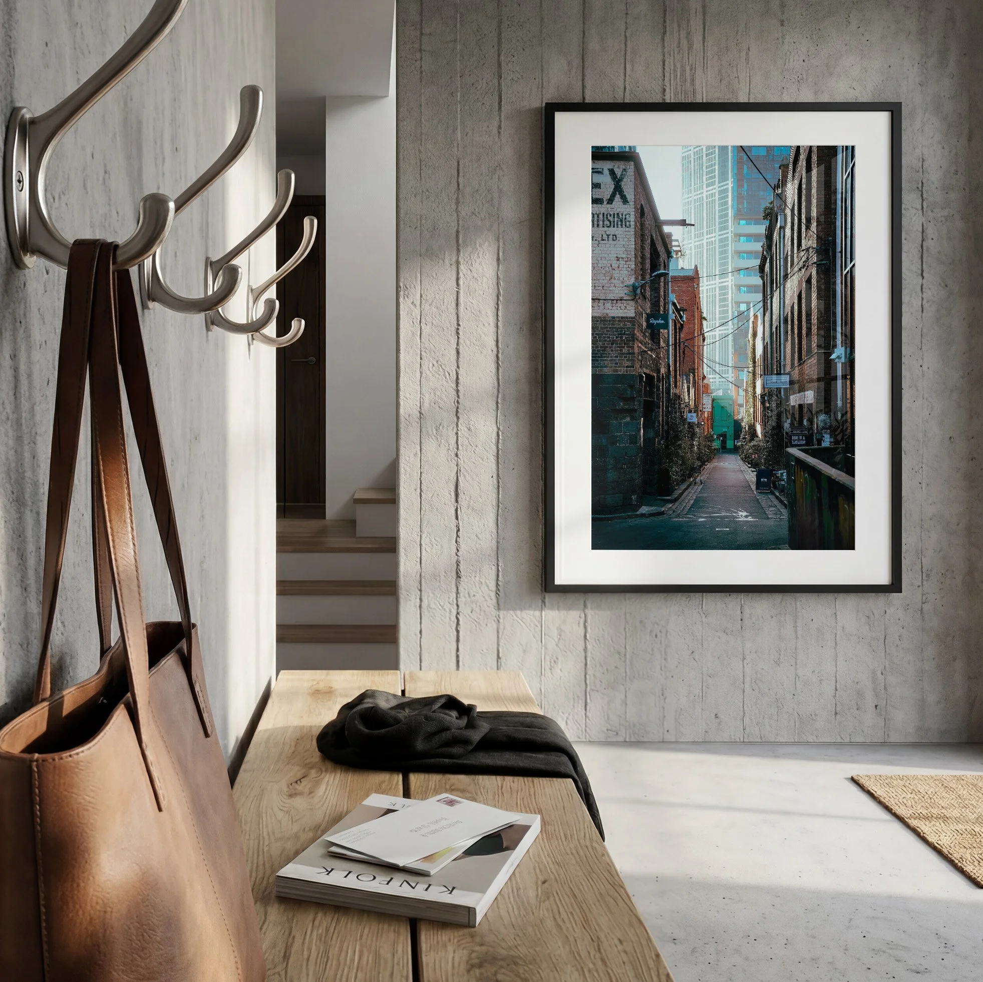 Melbourne laneway photography print displayed in a black frame with white mat in a contemporary concrete entryway with timber bench.