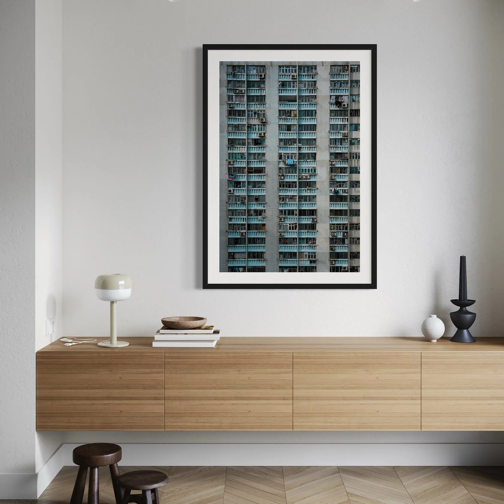 Framed Hong Kong architecture print displayed above a light wood sideboard in a modern minimalist interior.