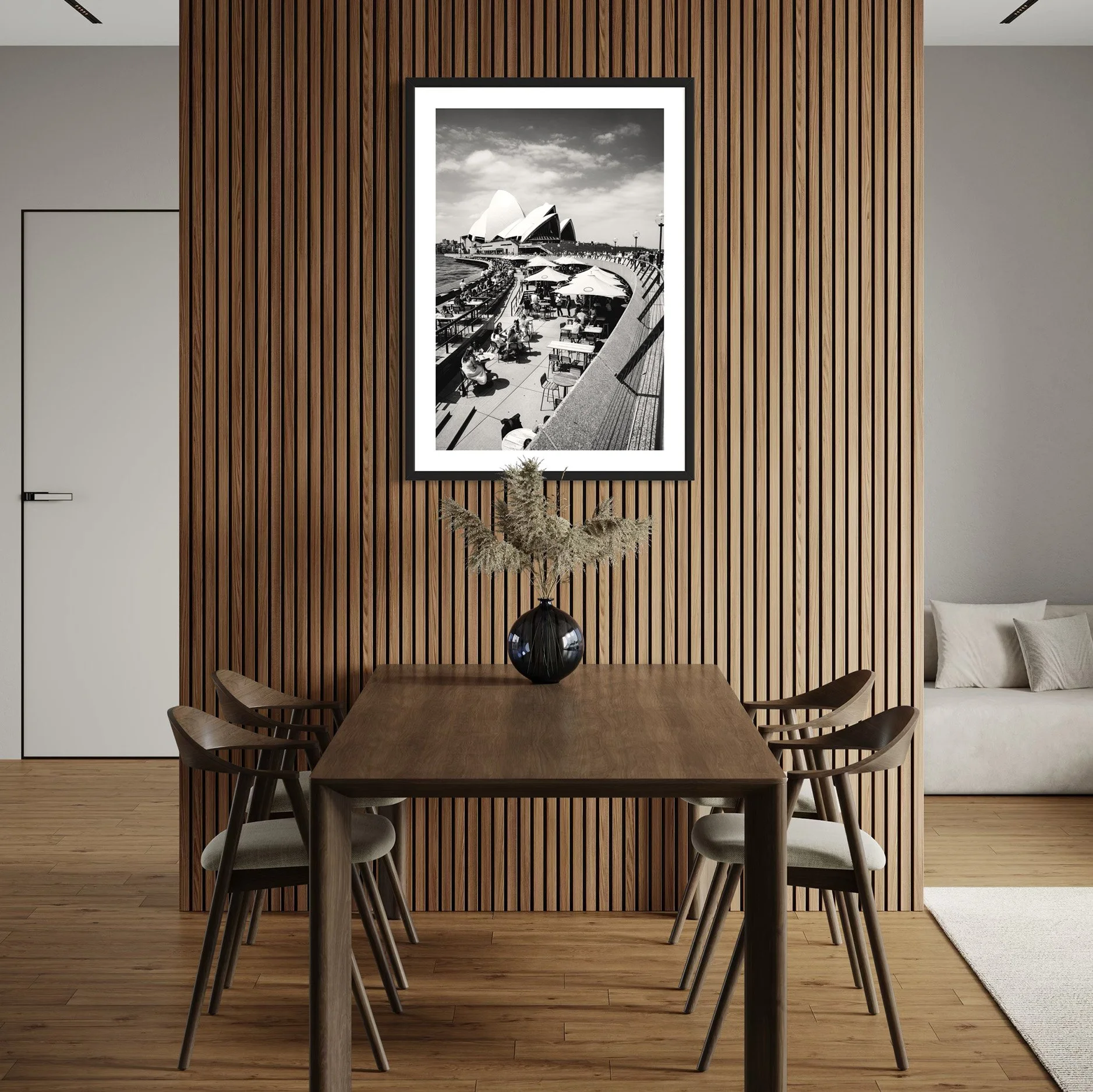 Black and white Sydney Opera House wall art displayed above a dining table against a timber feature wall, adding architectural character to a contemporary interior.