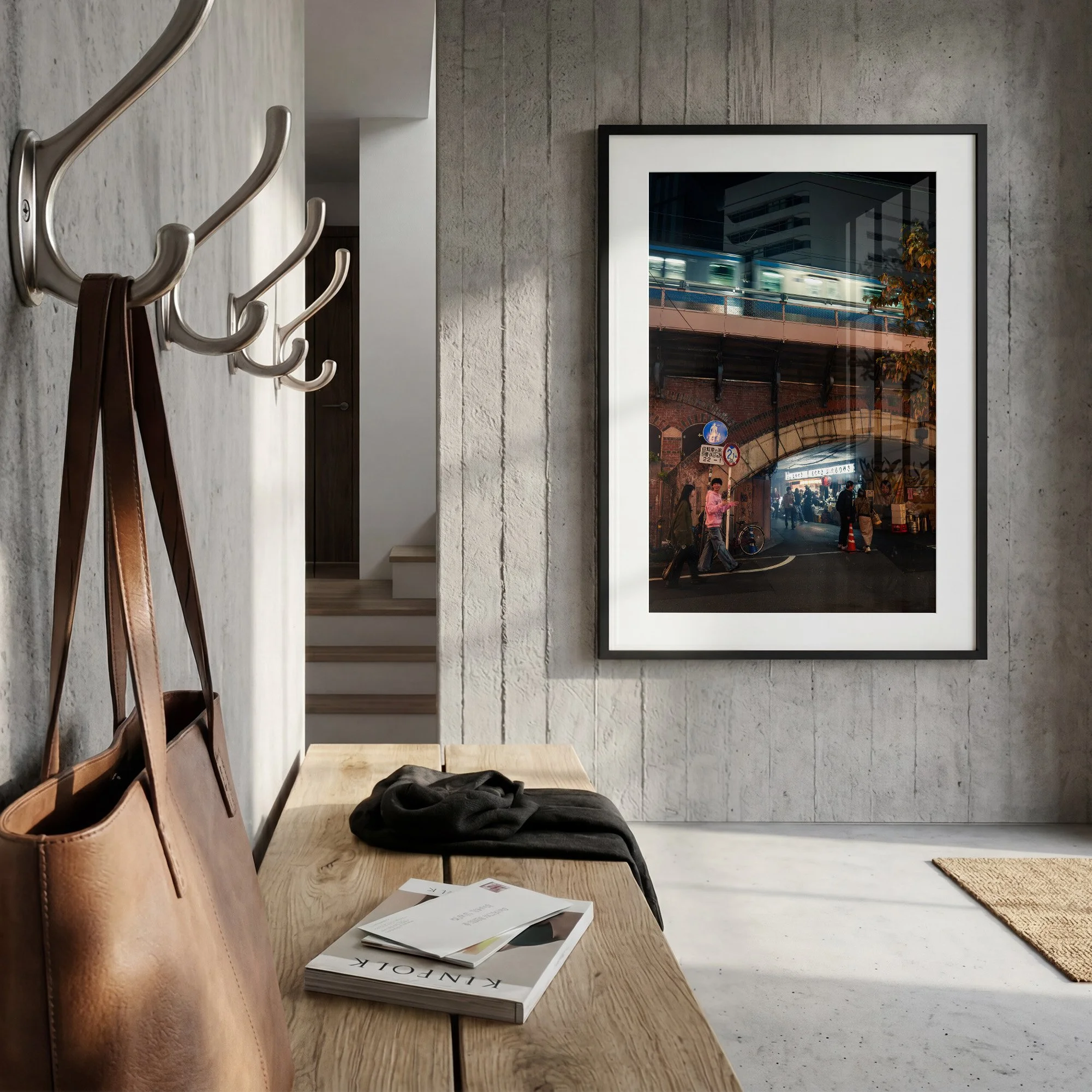 Tokyo night street photography print featuring a moving train above a brick railway arch, displayed in a black frame with white mat on a concrete wall.
