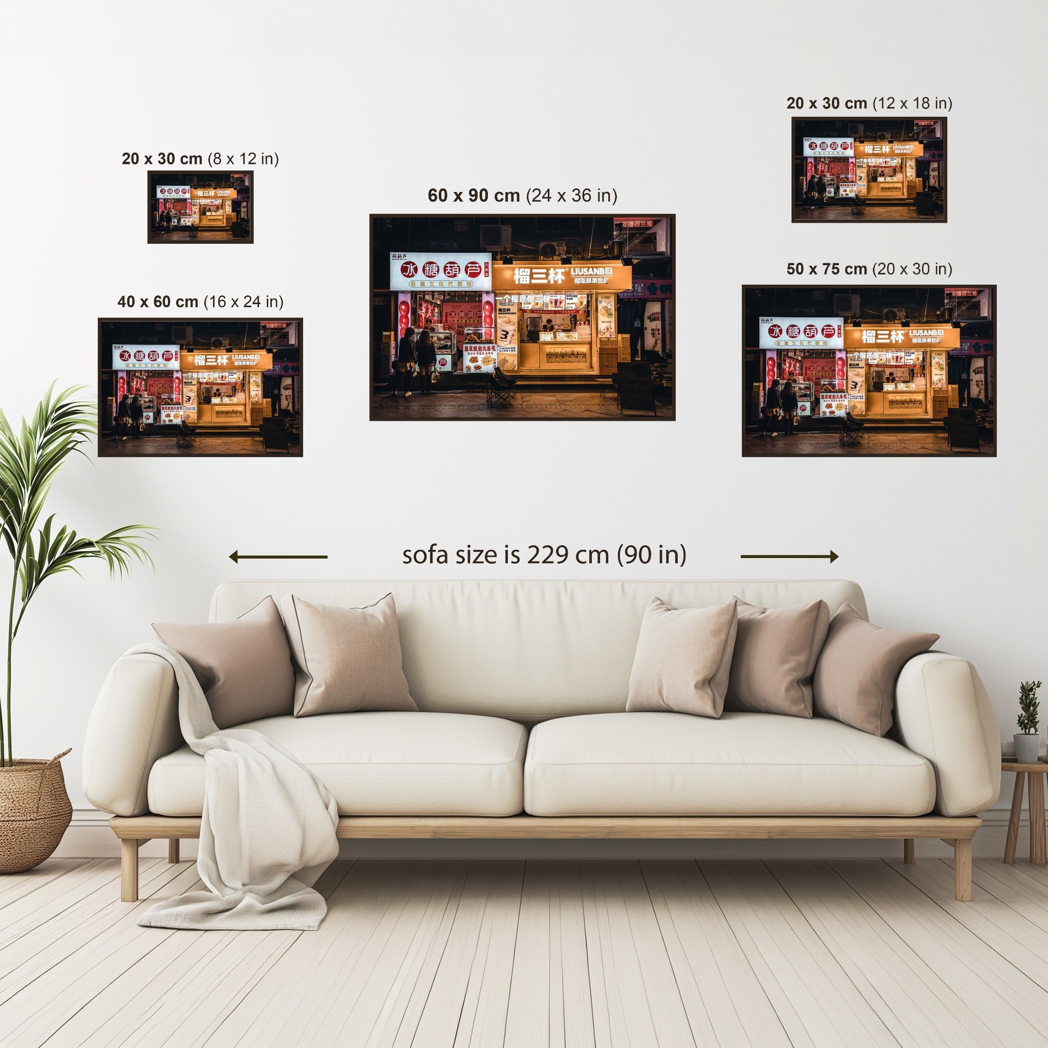 Size guide showing the Guangzhou Food Shops print displayed above a sofa, comparing all available print sizes from 20 × 30 cm (8 × 12 in) to 60 × 90 cm (24 × 36 in).