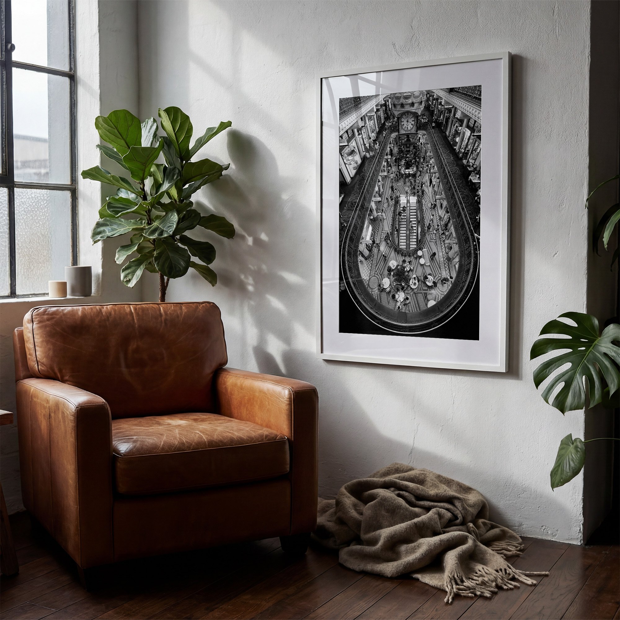 Queen Victoria Building black and white photography print displayed in a white frame beside a leather armchair in a warm contemporary interior.