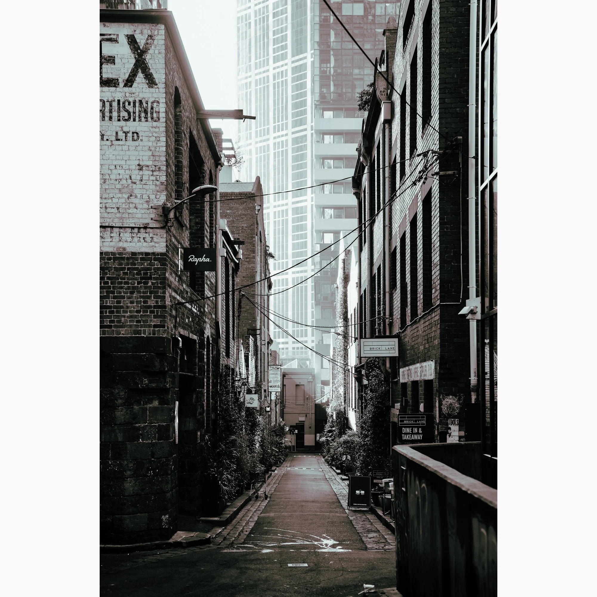 Black and white Melbourne laneway photography artwork featuring narrow city streets, brick architecture and modern towers.