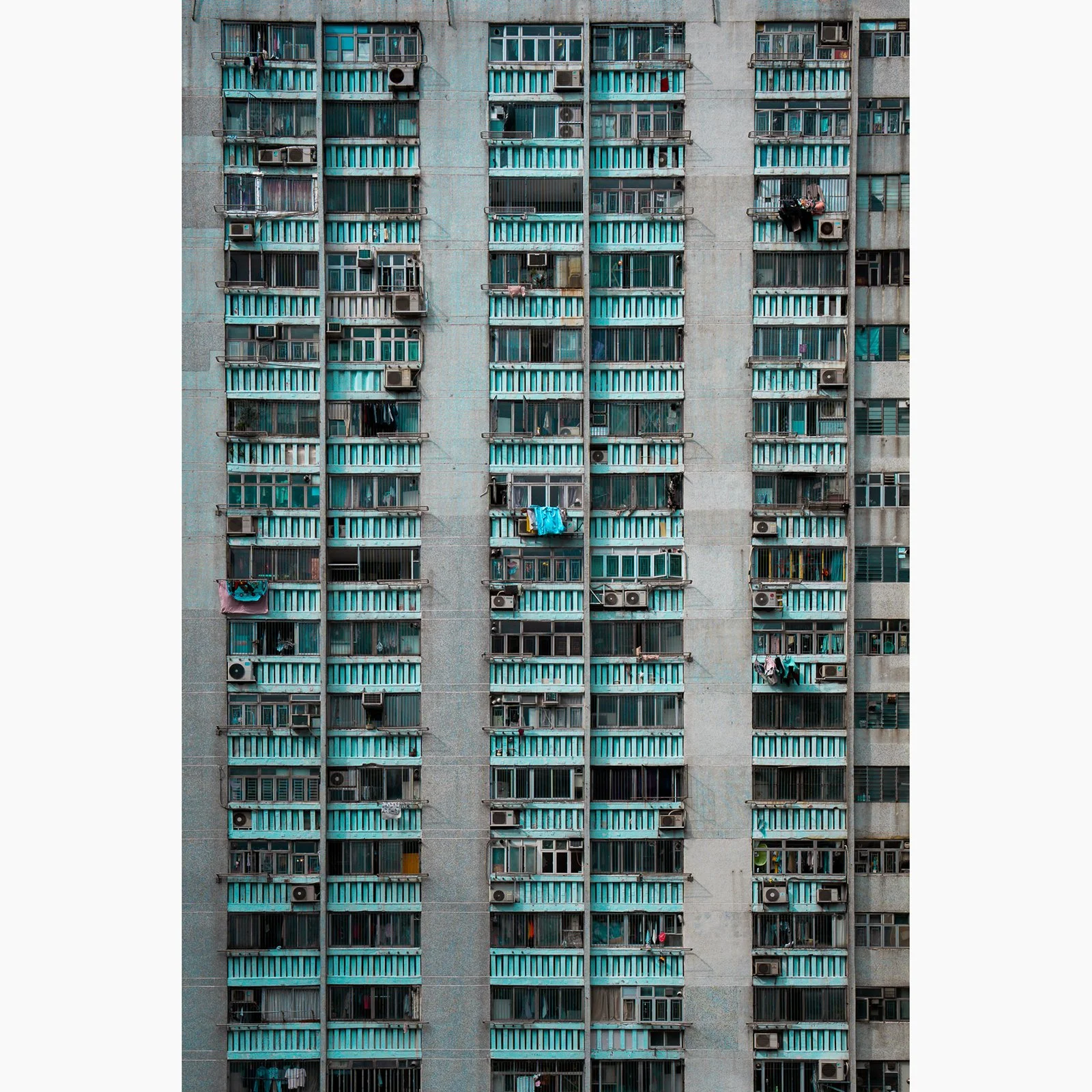 Colour photograph of a dense Hong Kong apartment building facade with repeating balconies and windows.