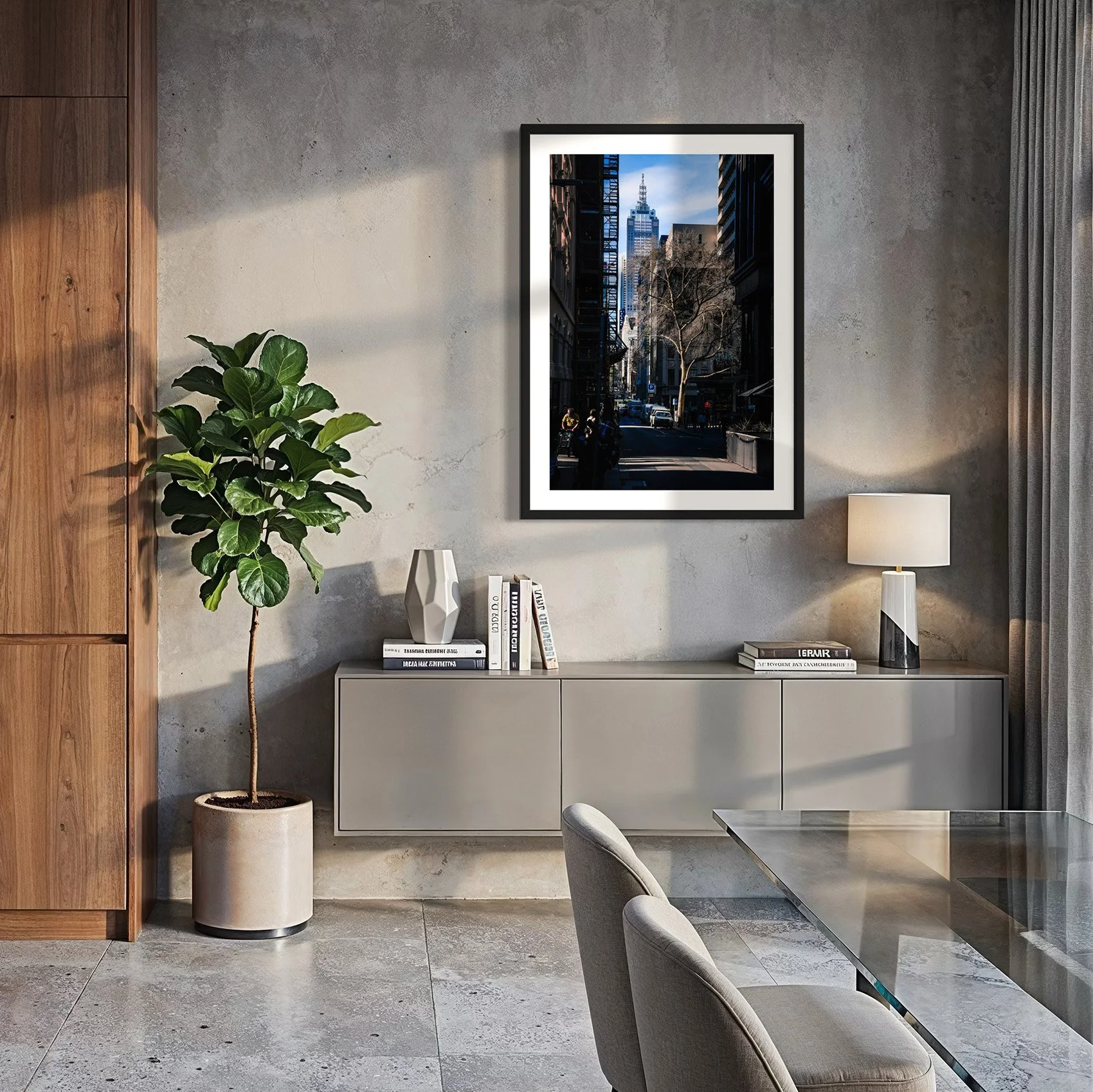 Framed Melbourne city photography print displayed above a floating sideboard in a modern dining room with concrete walls.