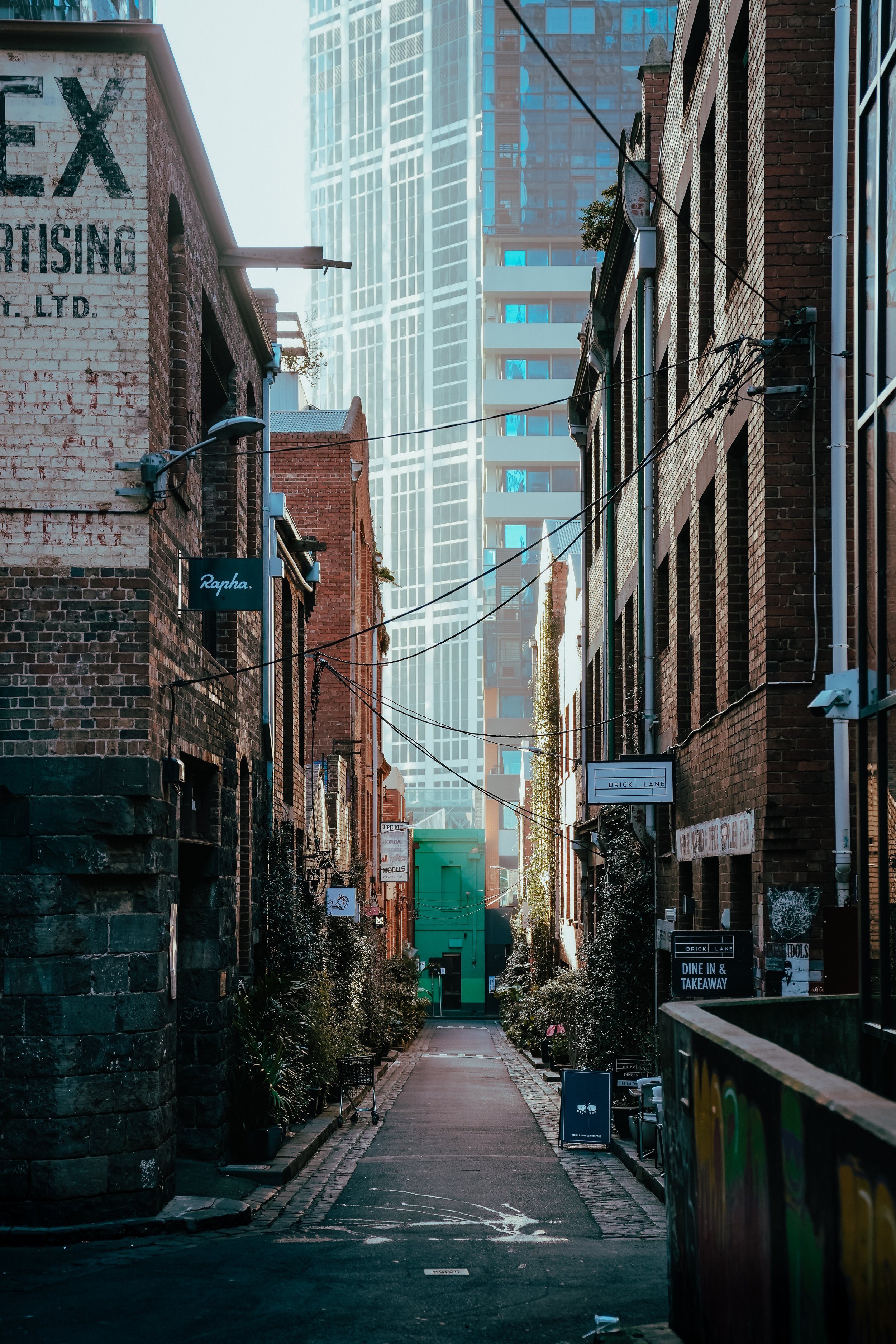 Melbourne laneway photography featuring historic brick buildings, modern skyscrapers and moody morning light in the city centre.