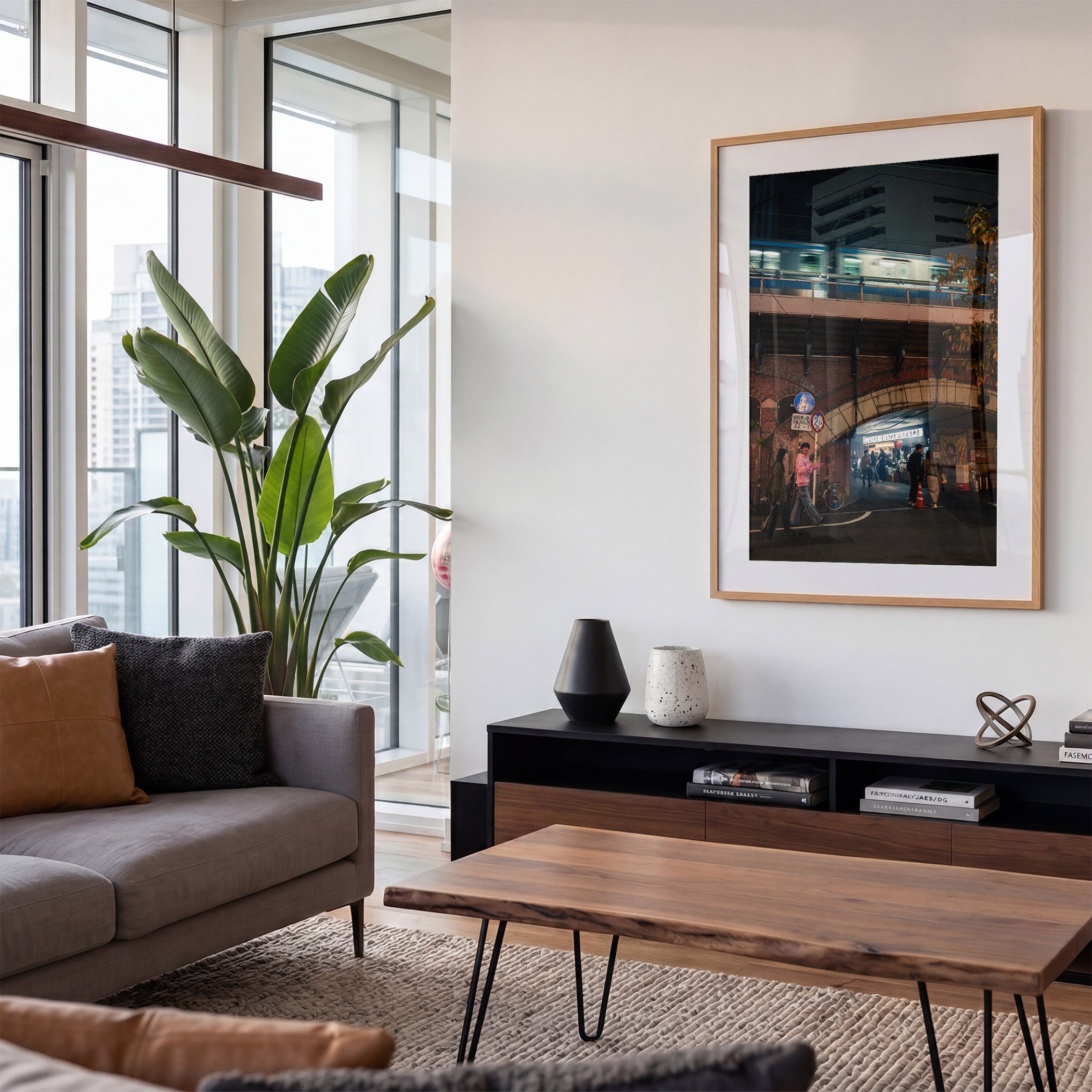 Tokyo night street photography print featuring a moving train above a brick railway arch, displayed in an oak frame with white mat in a contemporary living room.