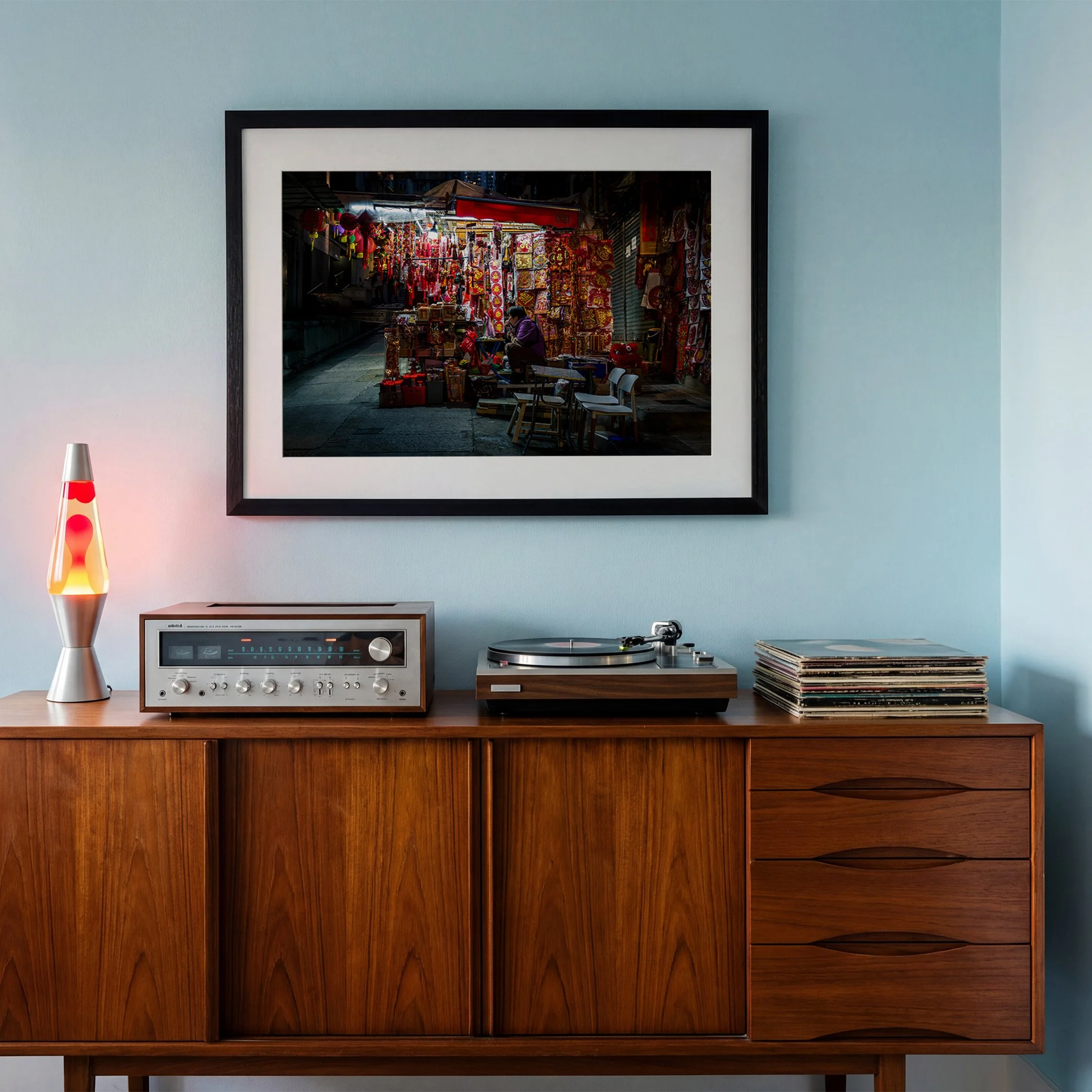 Hong Kong street photography print featuring a colourful night market stall, displayed in a black frame above a mid-century sideboard and record player.