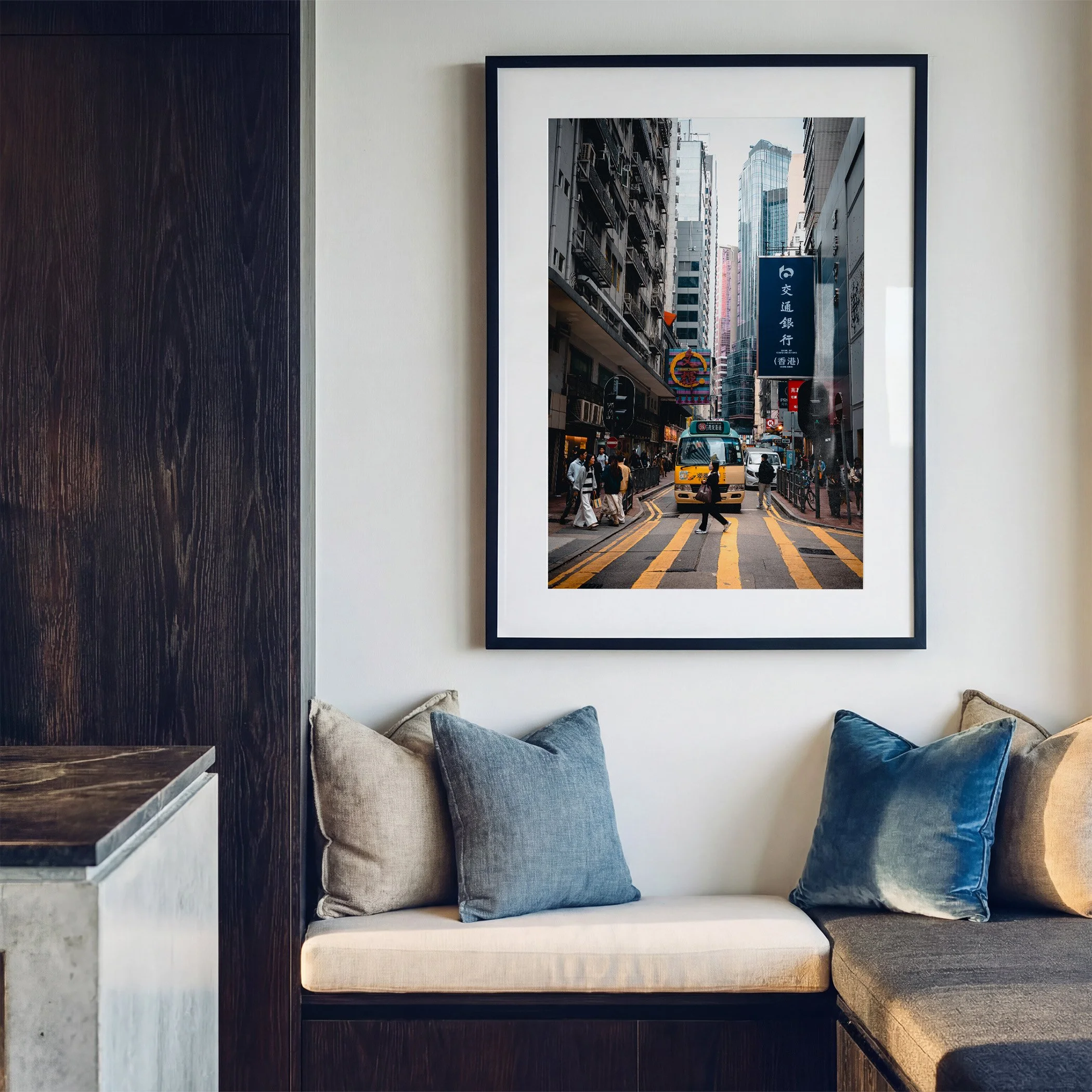 Hong Kong street photography print featuring a yellow minibus, displayed in a black frame with white mat above a contemporary window seat with blue cushions.