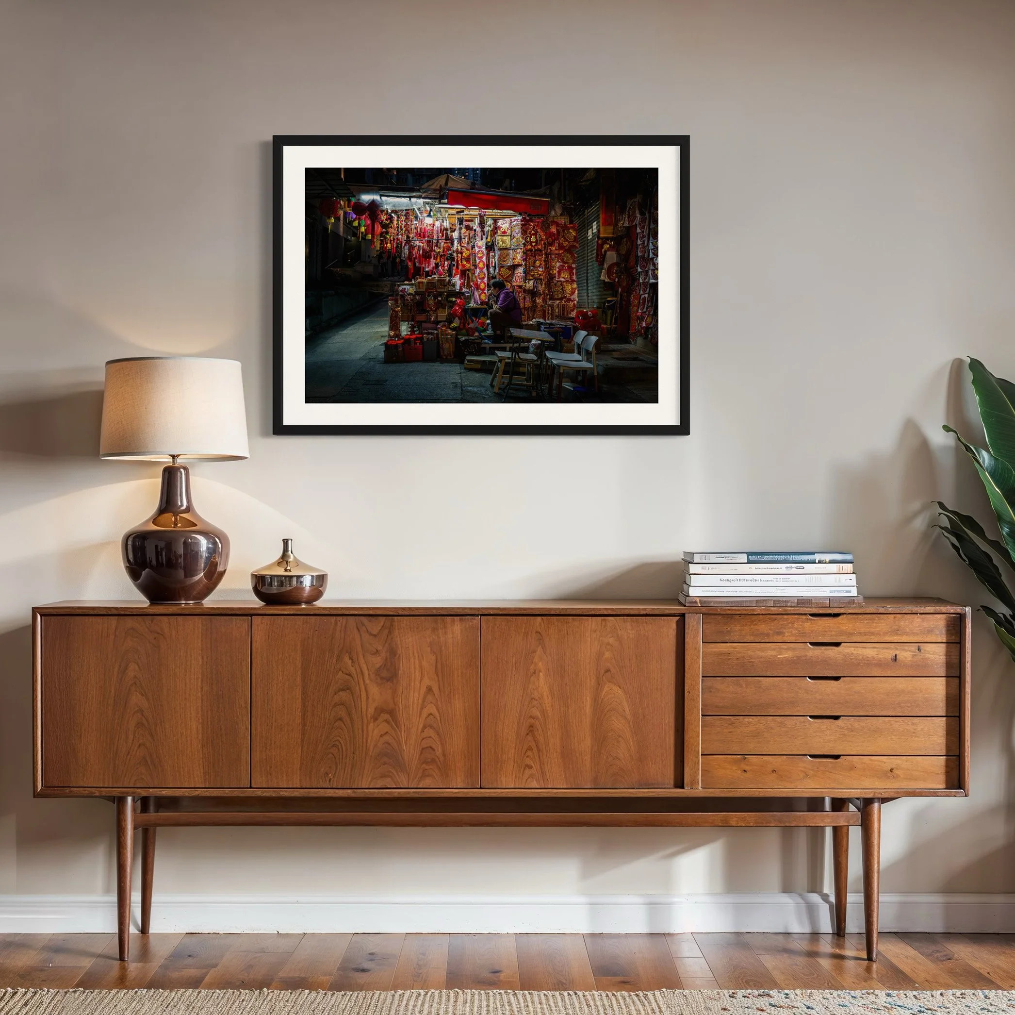 Hong Kong market stall fine art photo print in a black frame above a mid-century timber sideboard in a contemporary living room.