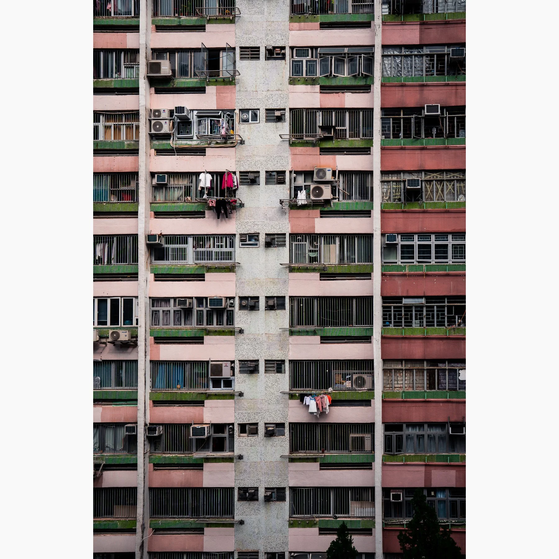 Hong Kong apartment building facade with balconies, laundry and repeating architectural patterns