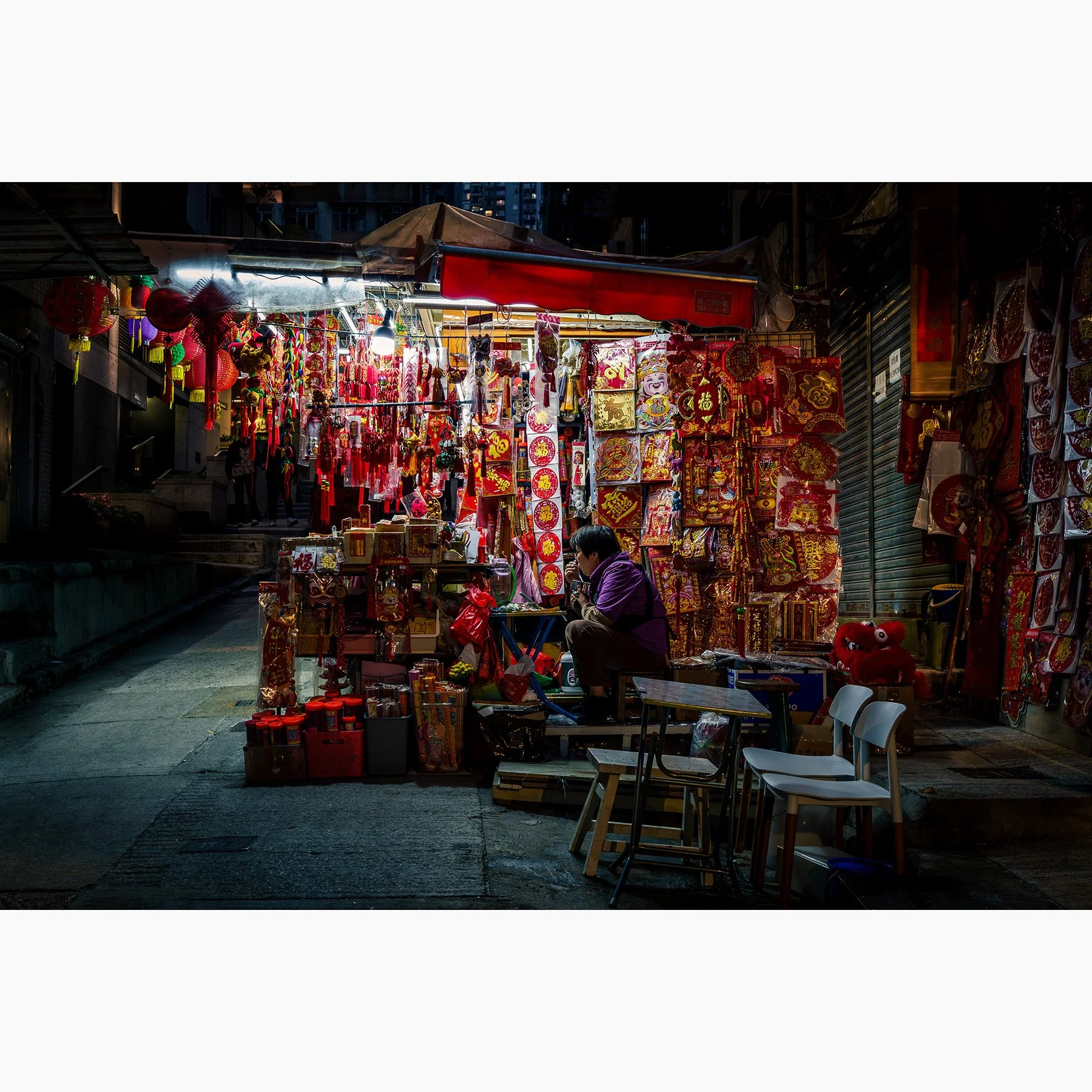 Hong Kong night market stall filled with red lanterns, decorations and warm light, photographed in the streets of Hong Kong.