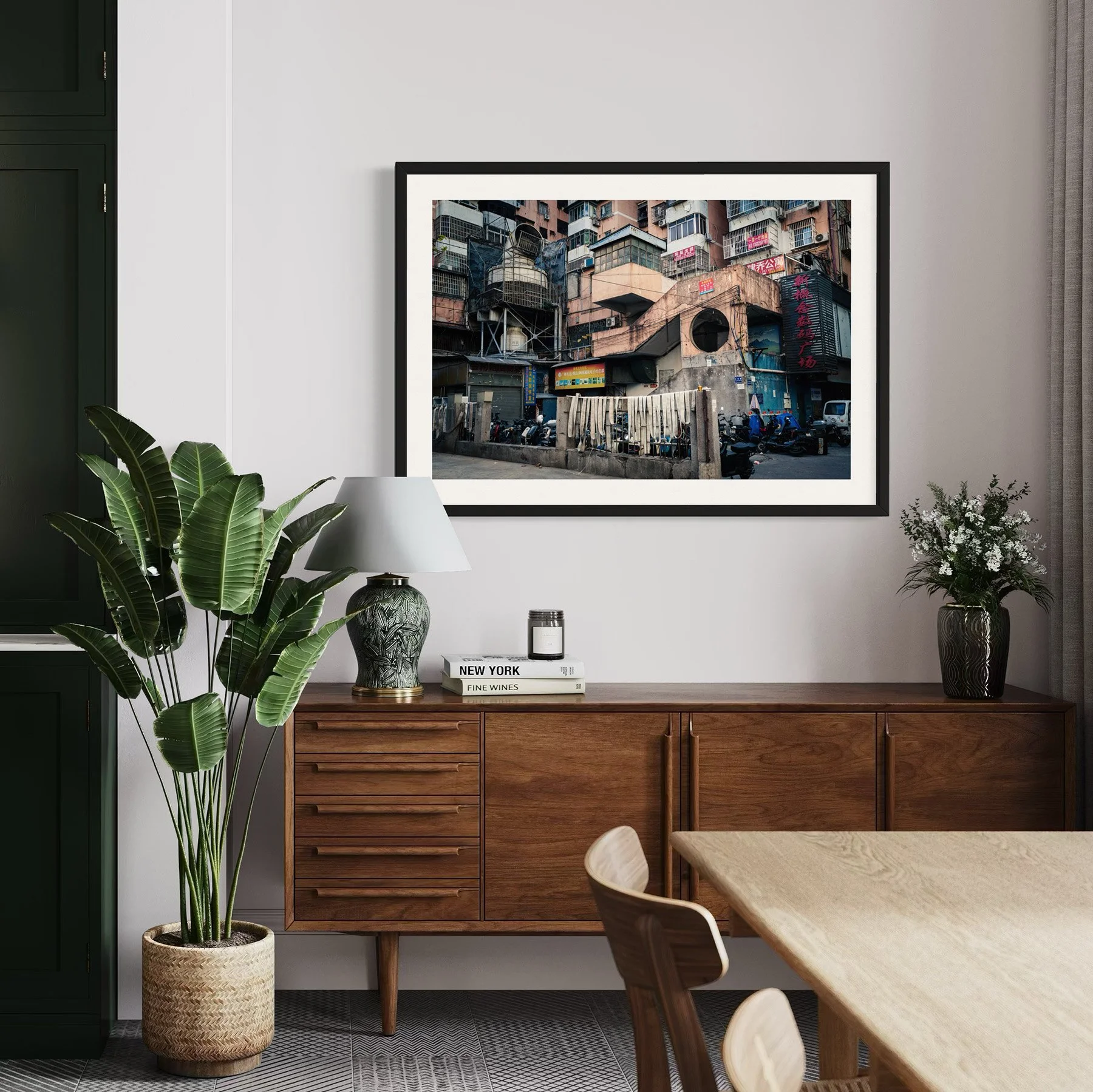 Framed Guangzhou architecture print above a walnut sideboard in a modern dining and living space.
