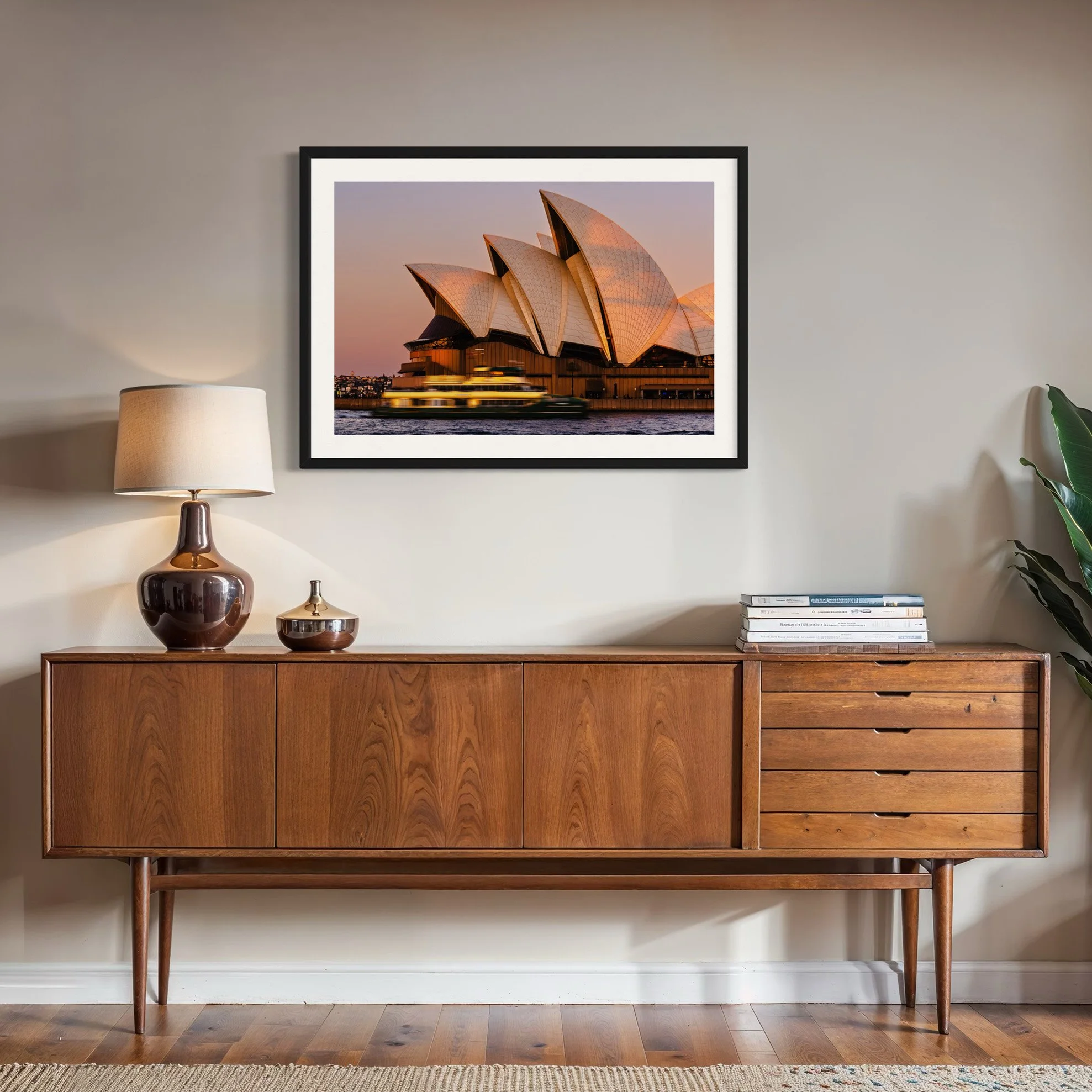 Framed Sydney Opera House sunset photograph displayed above a mid-century timber sideboard.