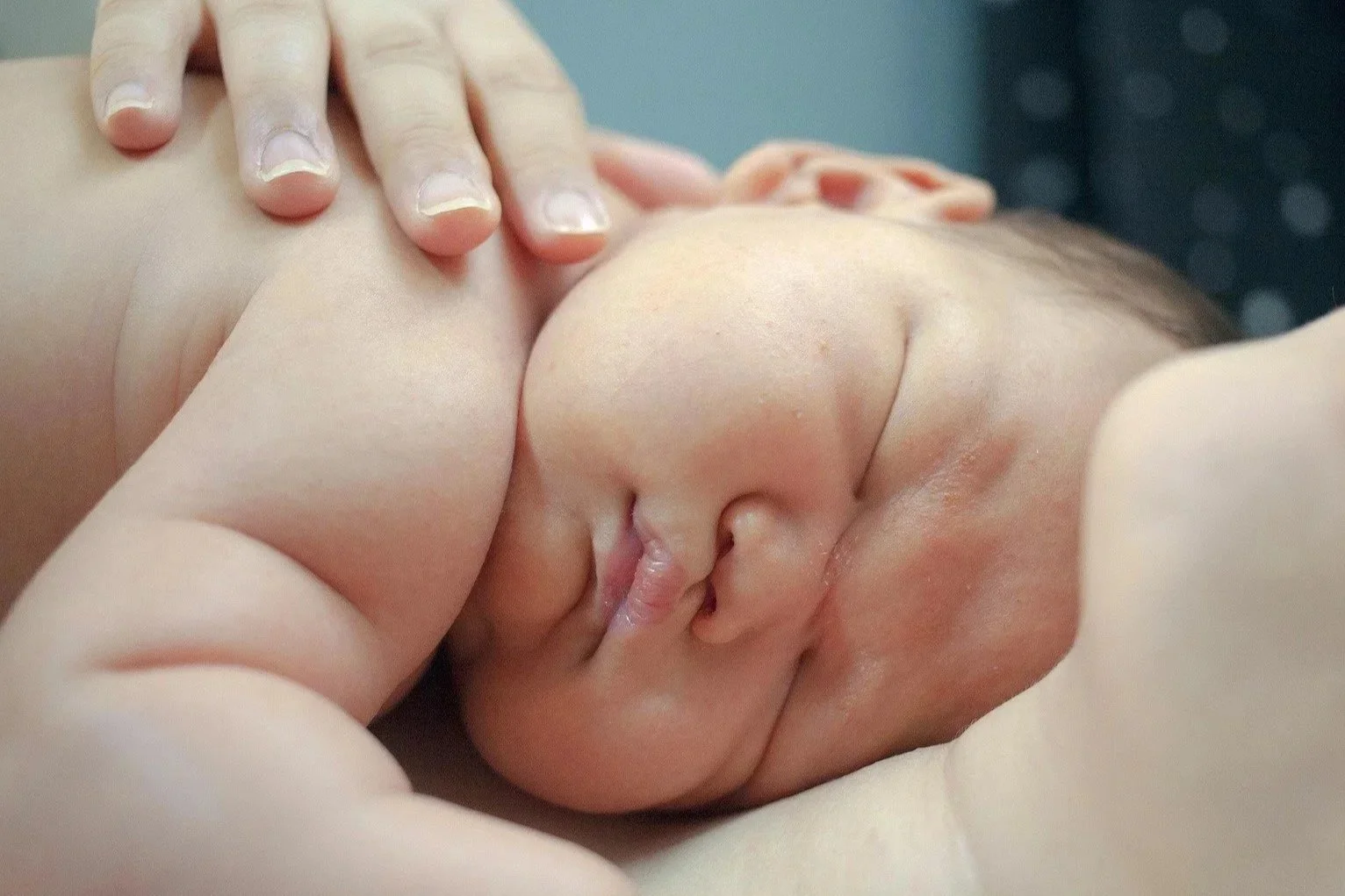Close-up of a person sleeping with their face pressed against a pillow.
