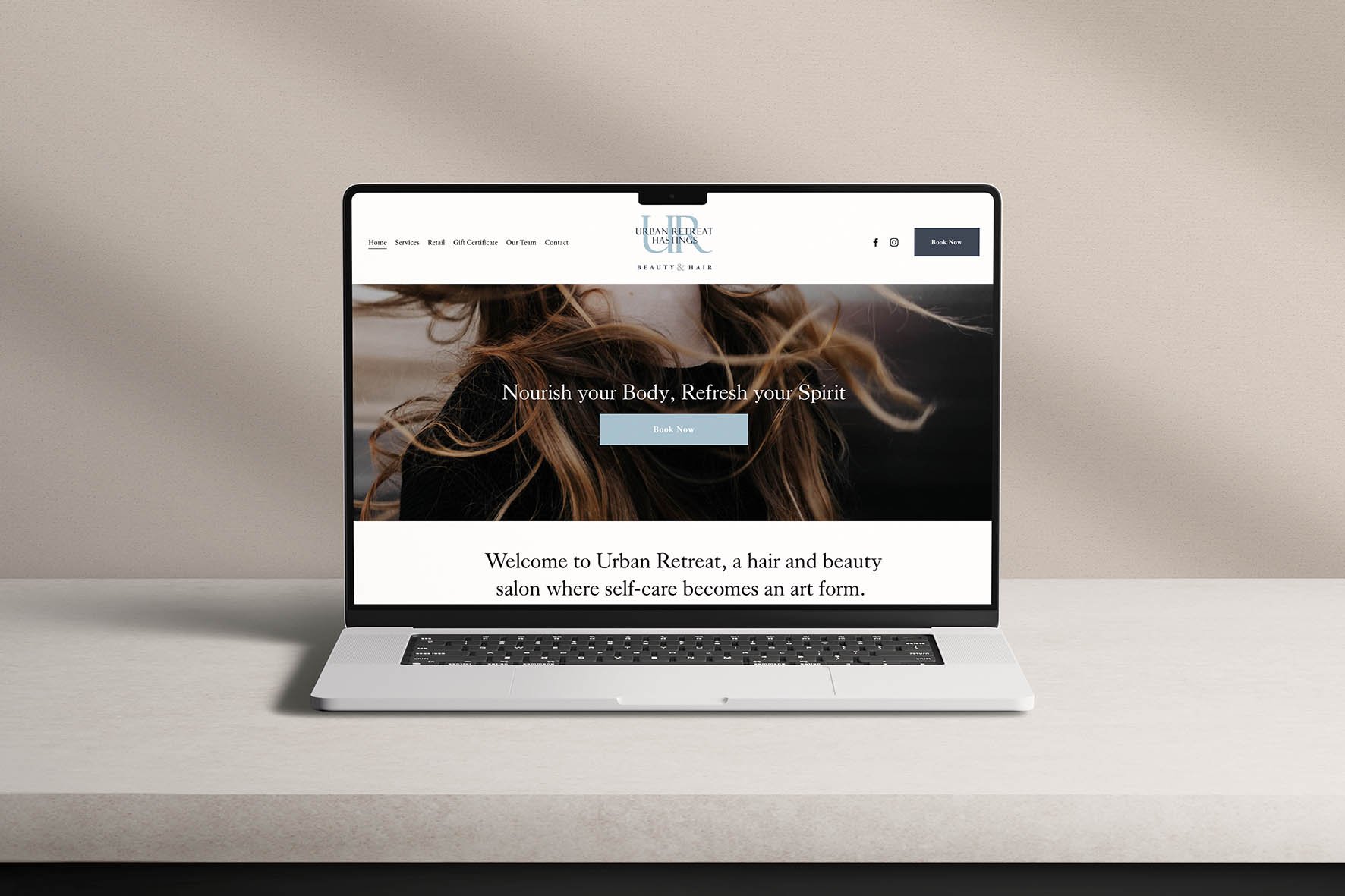 Laptop on a white desk displaying a website for Urban Retreat, a hair and beauty salon, with a large image of a woman with flowing hair, and text encouraging self-care.