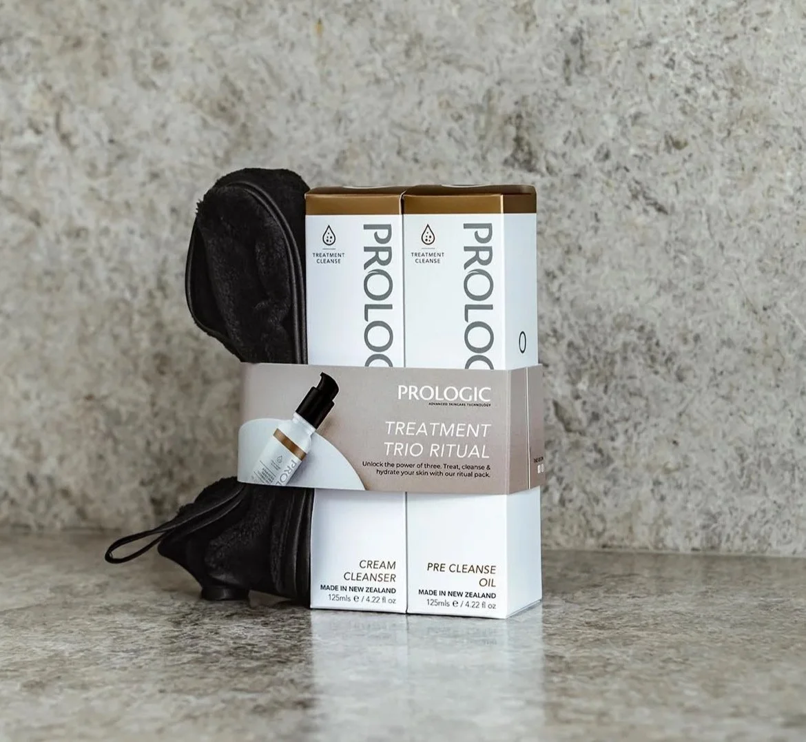 Prologic skincare treatment trio ritual set includes cream cleanser, pre-cleanse oil, and a black pouch, with packaging indicating skincare in New Zealand.