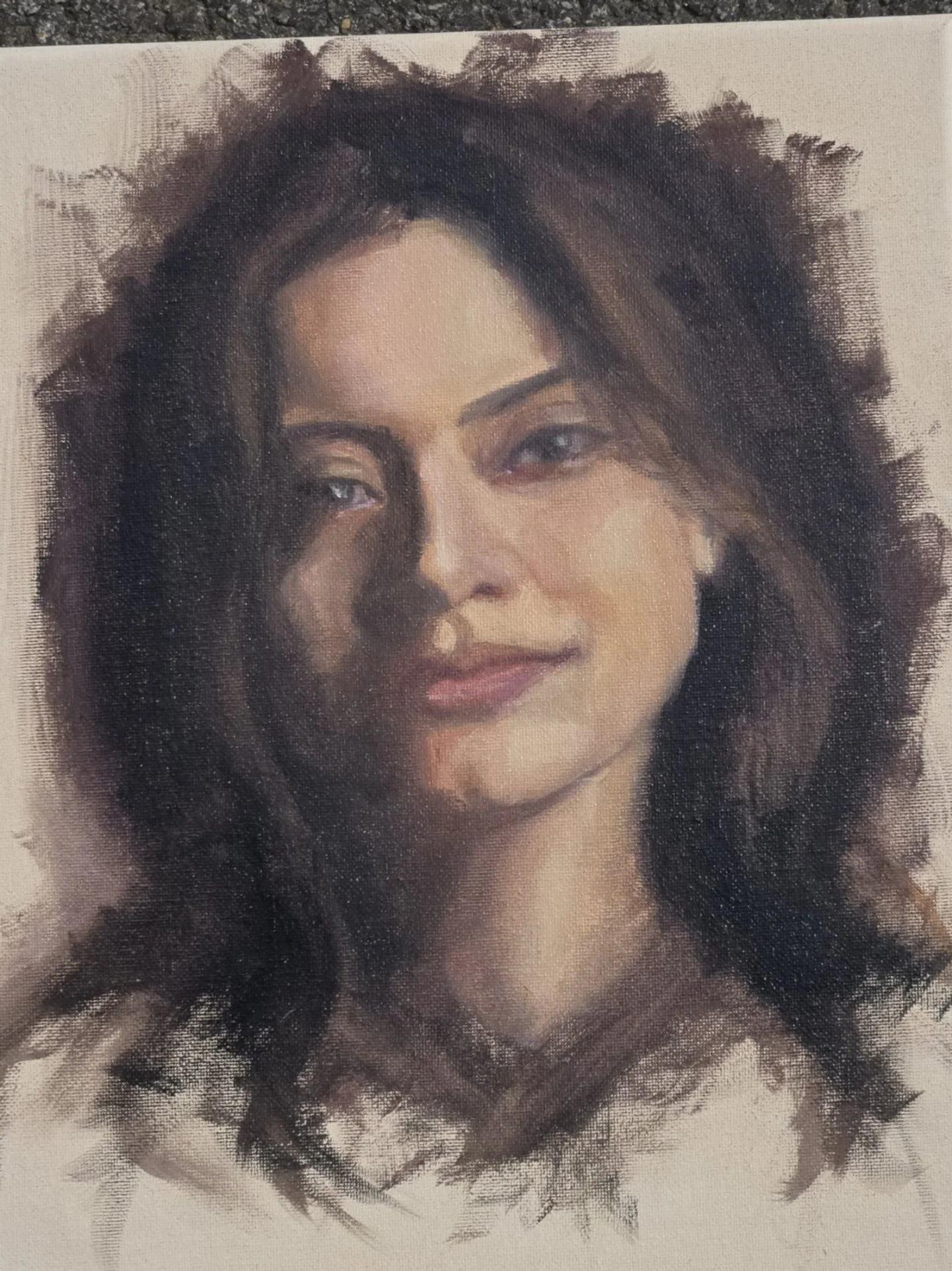 A portrait of a woman with wavy brown hair, blue eyes, and a gentle smile, painted in a realistic style.