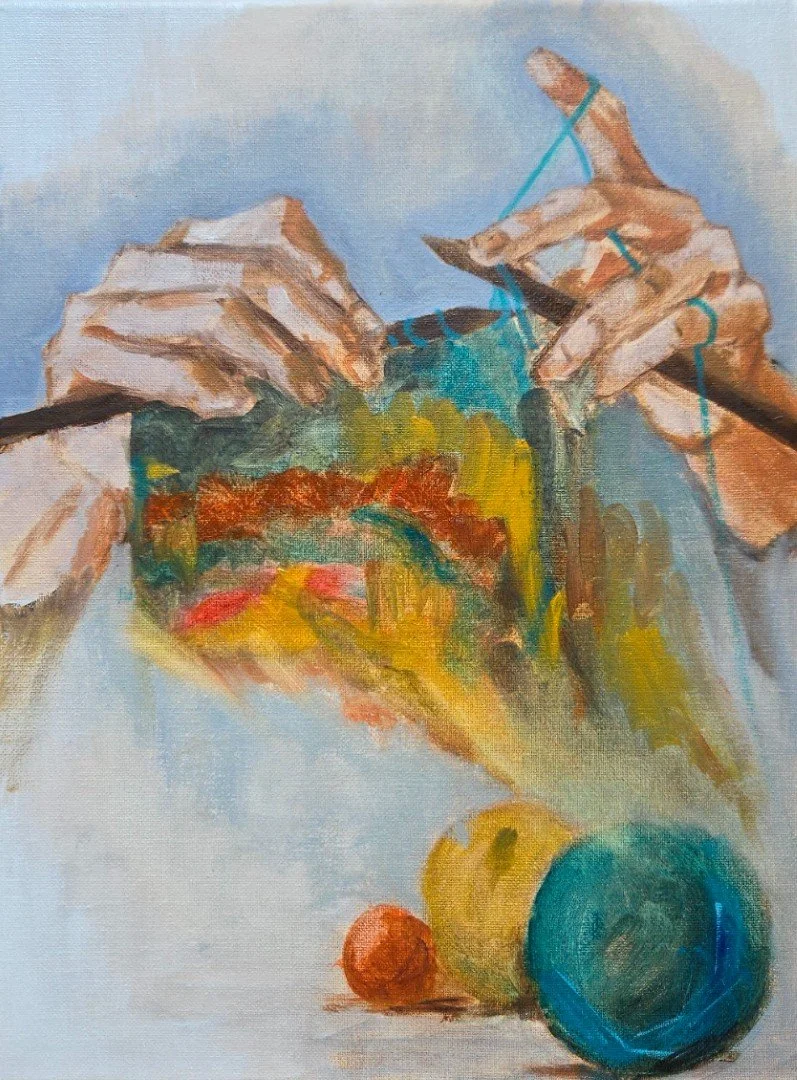 An abstract painting depicting hands knitting with blue yarn, colorful balls of yarn in the foreground, and a light blue background.