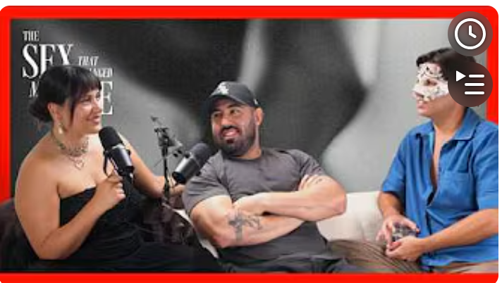 Three people sitting and talking; a woman in a black dress with a necklace speaking into a microphone, a man in a gray t-shirt and baseball cap with arms crossed, and another person with a blue shirt and white mask or face covering.