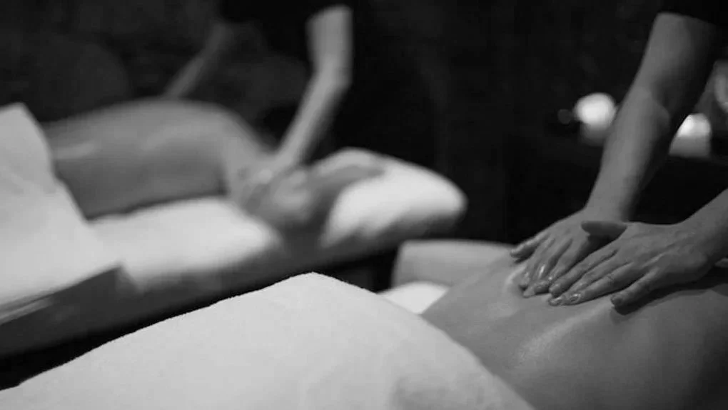 Close-up of hands and a back massage in a spa setting, black and white photo