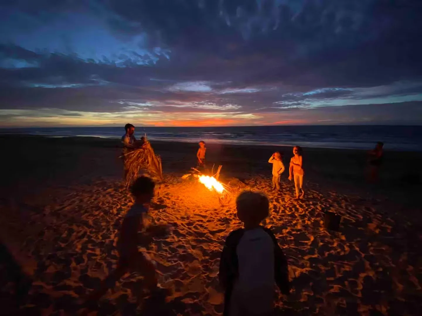 Sunset kids around bonfire at Jungle Hut in Dundee Beach