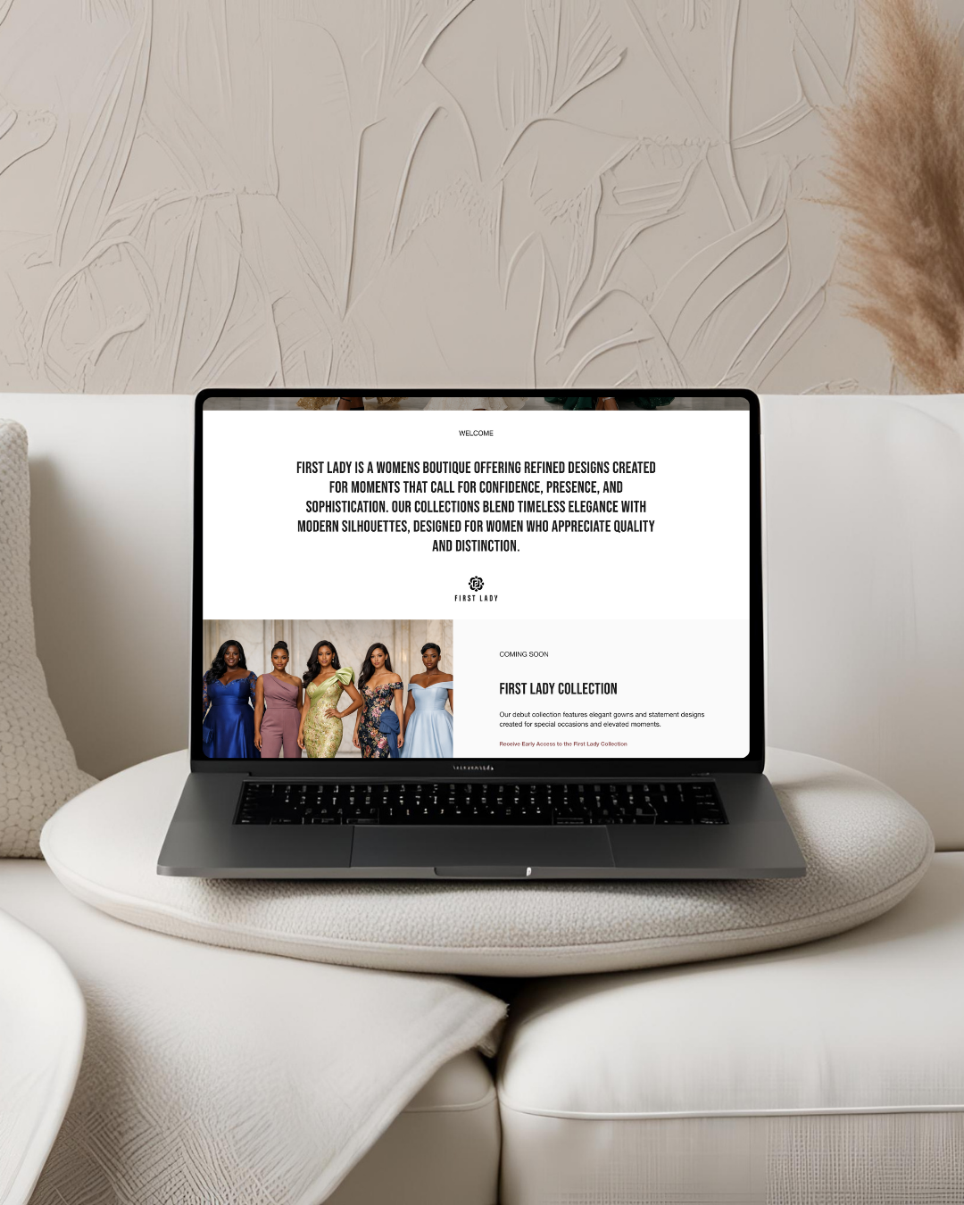 Laptop on a cozy white couch displaying a website for First Lady, a women's boutique, featuring a collection of elegant dresses and models.