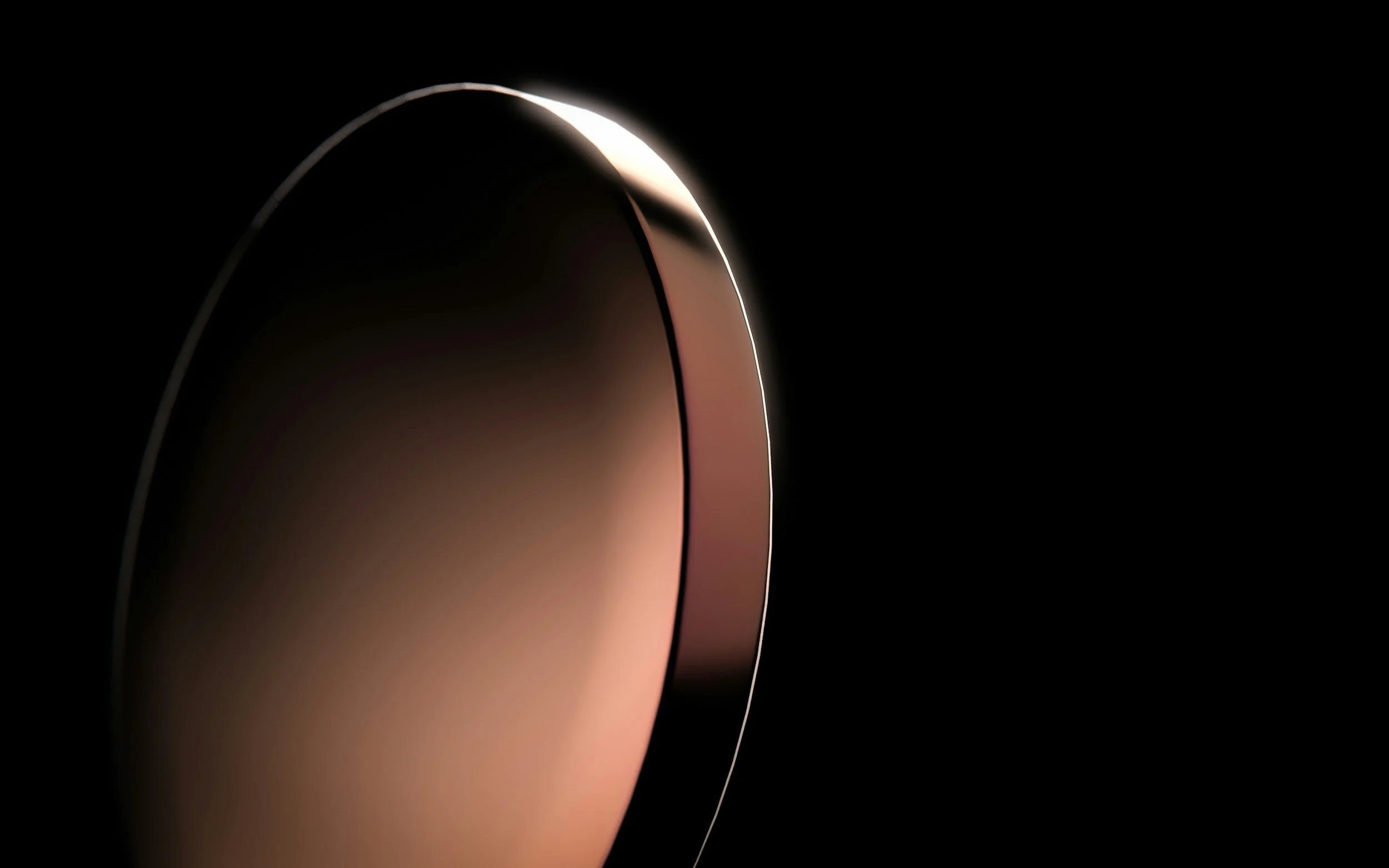 Close-up of a sleek, curved electronic device with a smooth surface against a black background, emphasizing curves and minimalistic design.