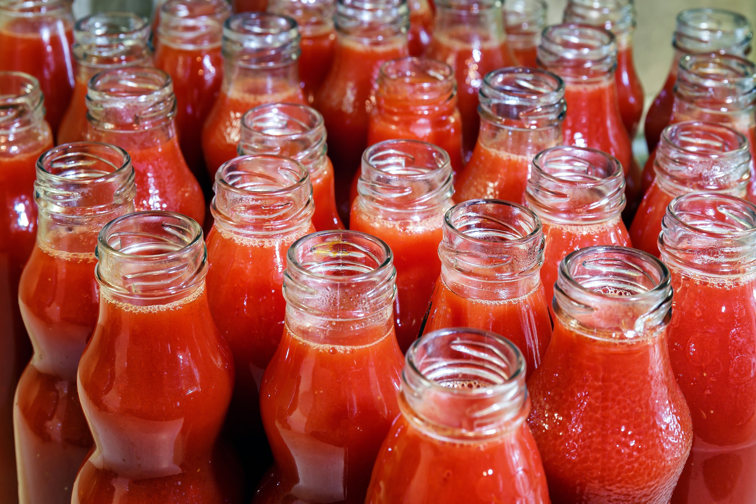 Glass bottles filled with red tomato juice at Sonoma Specialty Foods.