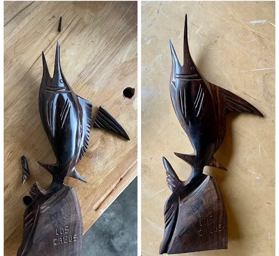 Carved wooden fish sculpture with a fish shape and detailed fins and tail.