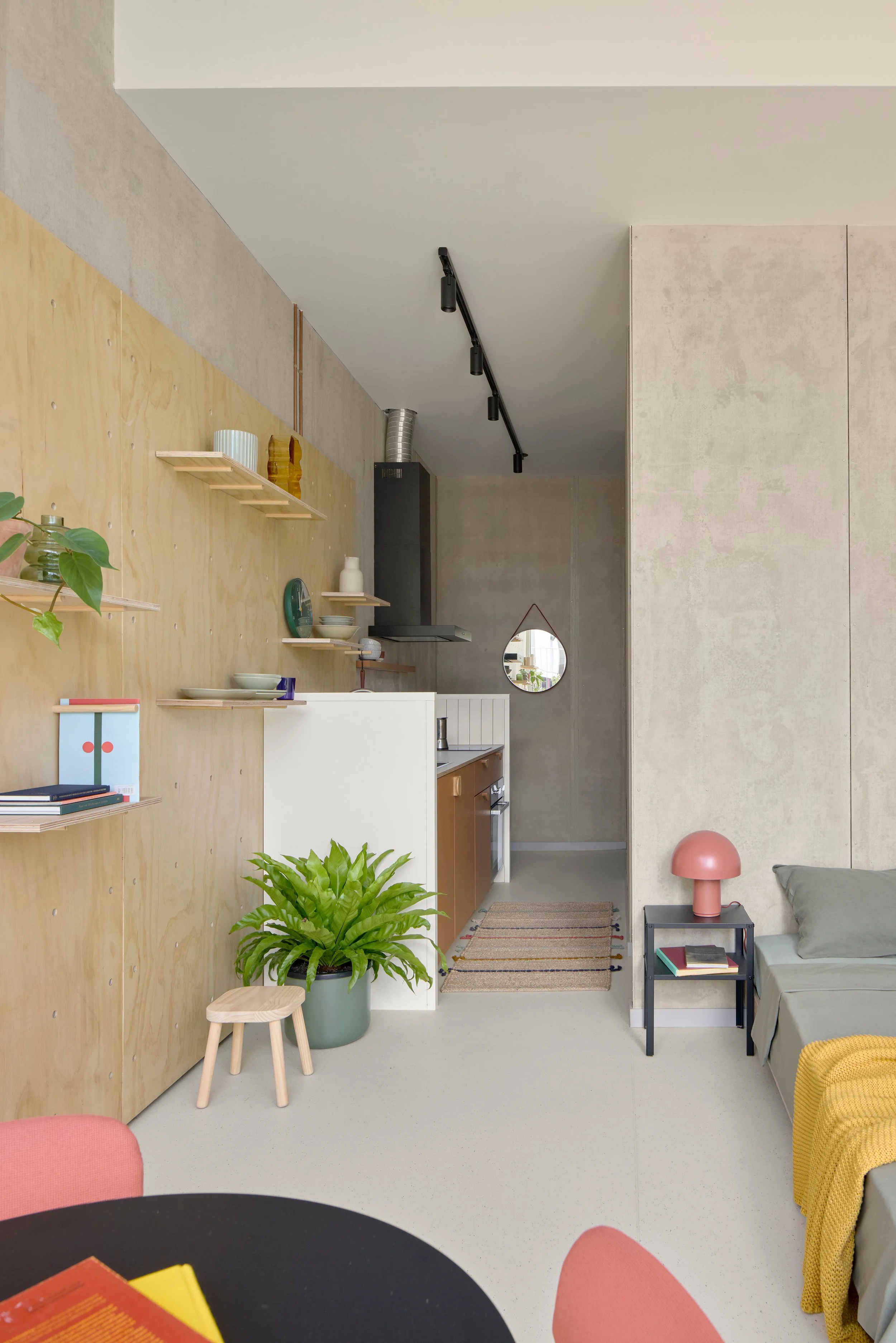 Teilhaus room showing galley kitchen, bed and dining table.