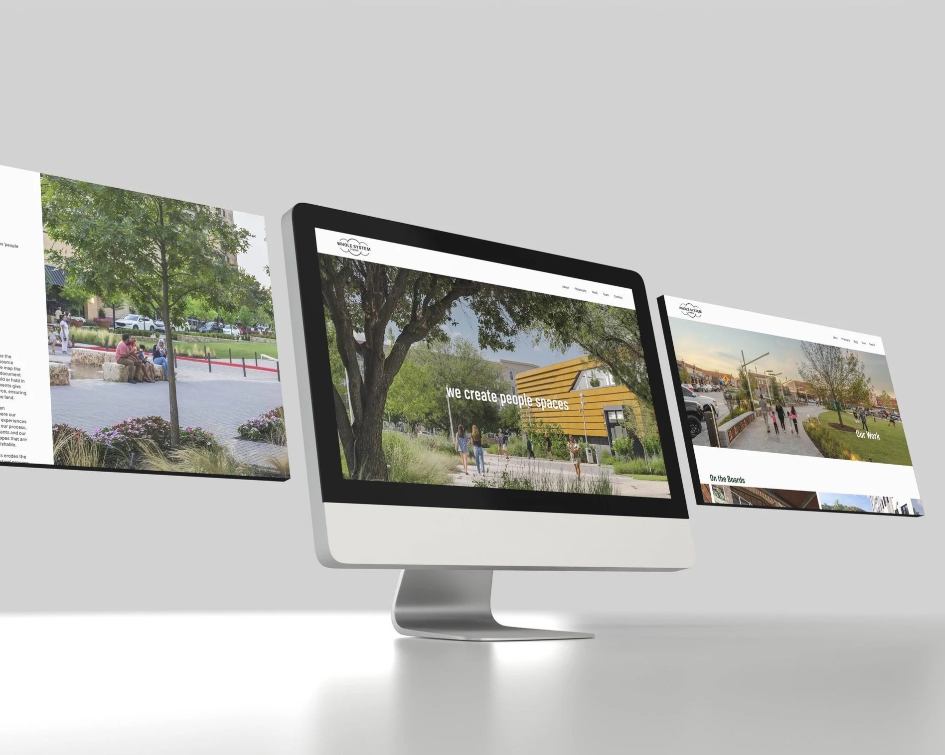 Multiple computer screens showcasing different landscape architecture websites on a modern, minimalistic white desk.