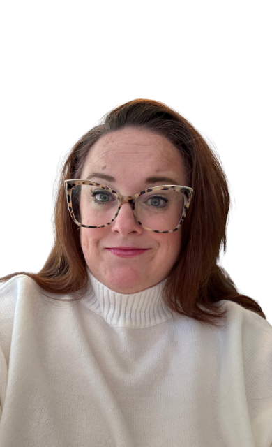 A woman with glasses and reddish-brown hair wearing a white turtleneck sweater.