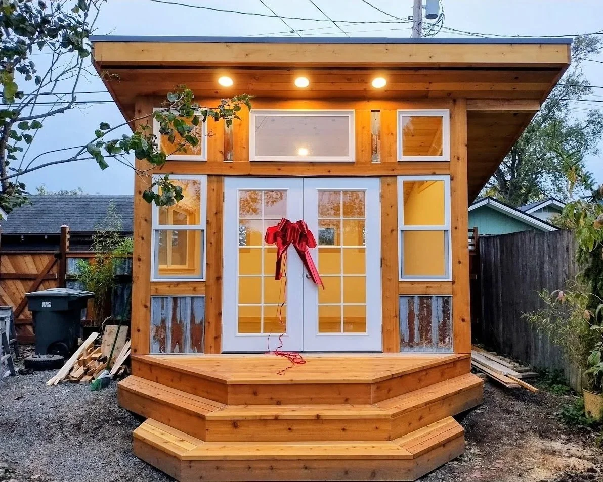 Backyard office with outswing glass French doors and plenty of windows and a small front porch with steps.