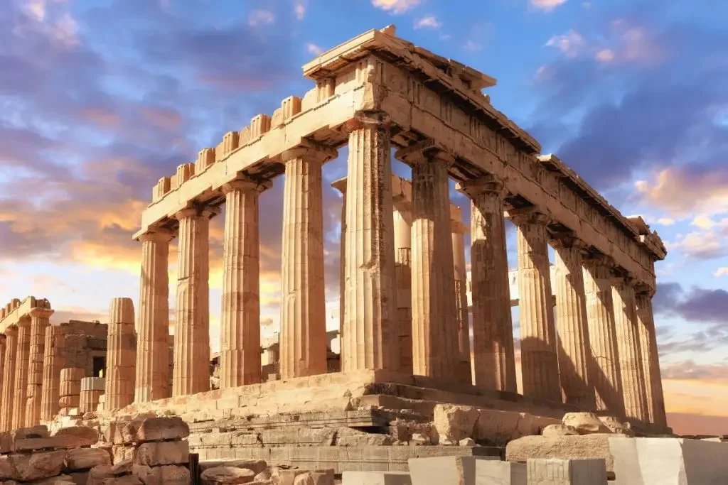 Ancient Greek Parthenon temple on the Acropolis hill at sunset with a colorful sky and clouds