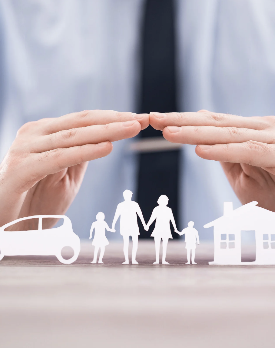 Hands hovering over paper cutouts of a car, family, and house, symbolizing protection and home security.
