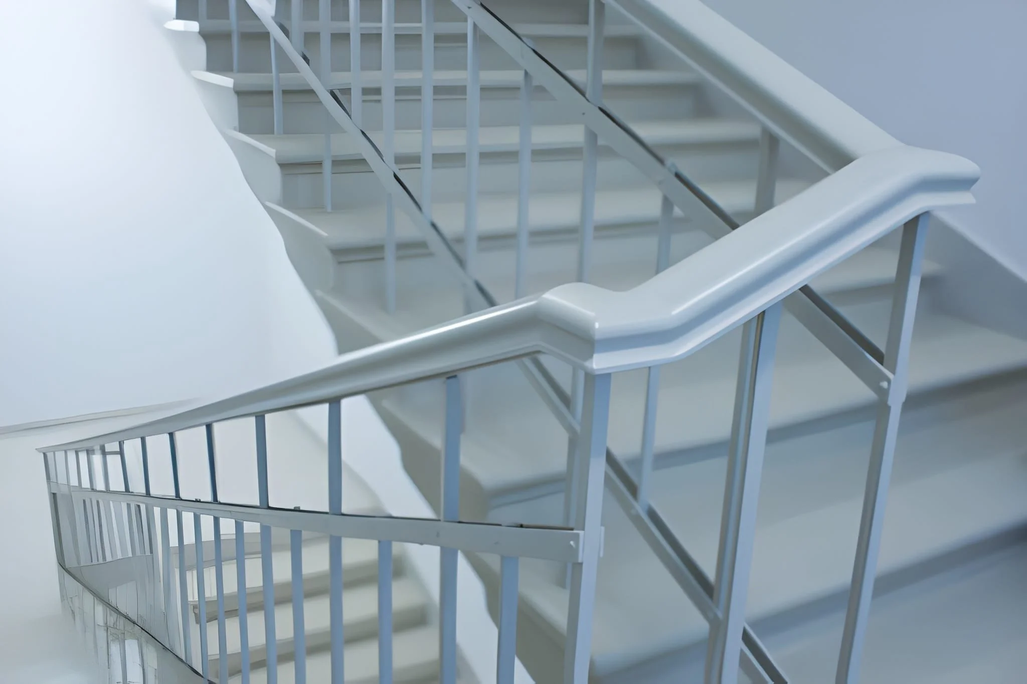 Top view of a white staircase with metal railings, with the image capturing the staircase from above, showing the steps and the handrail.