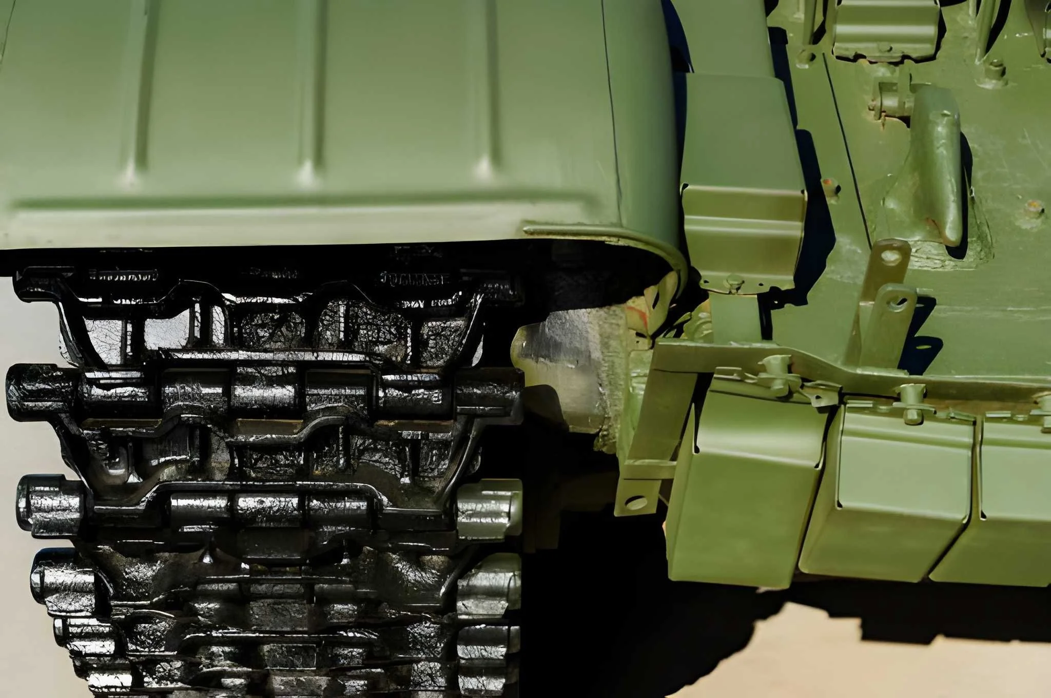 Close-up of a green military or tactical vehicle, showing parts of its exterior and mounting brackets.