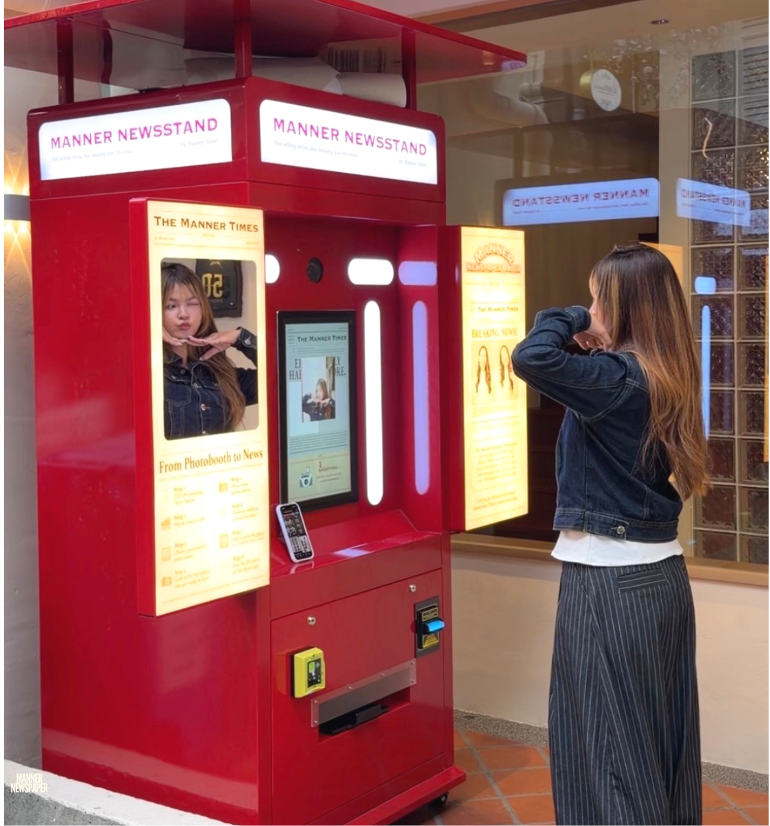 A girl posing in front of a Newspaper Photobooth Machine 