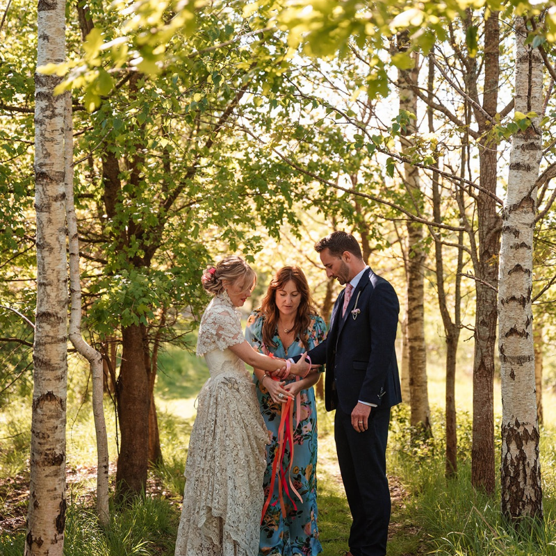 Bride and groom standing lakeside during an outdoor wedding ceremony in Hampshire officiated by Everlong Ceremonies