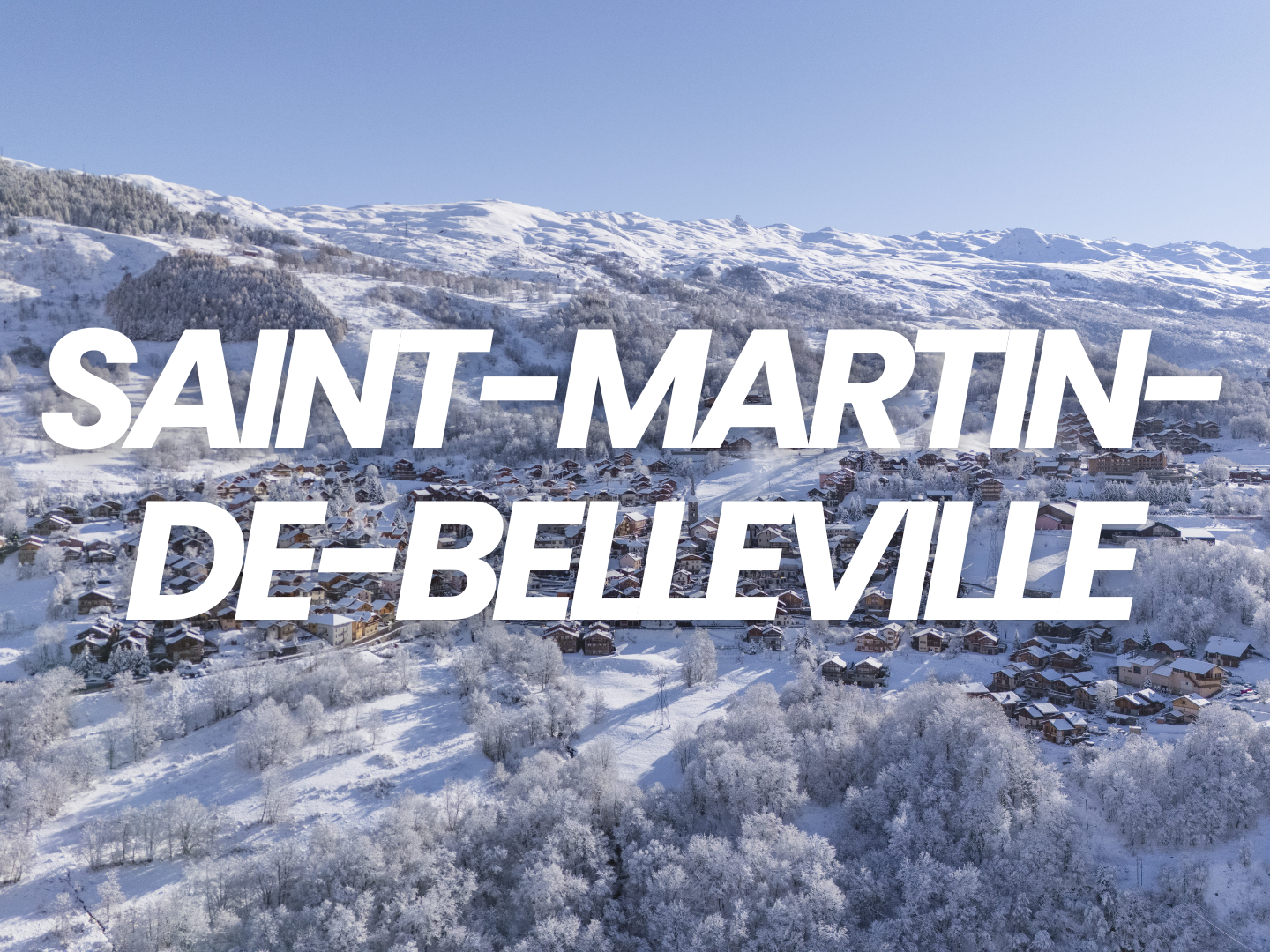 Vue aérienne d'un village enneigé dans les montagnes, avec le texte 'Saint-Martin-de-Belleville' inscrite en blanc en travers de l'image.
