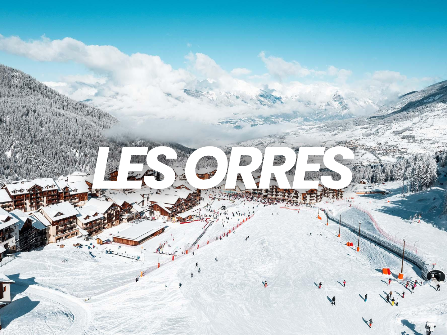 Station de ski et village à Les Orres, dans les Alpes françaises, avec des montagnes enneigées en arrière-plan et des skieurs sur les pistes.