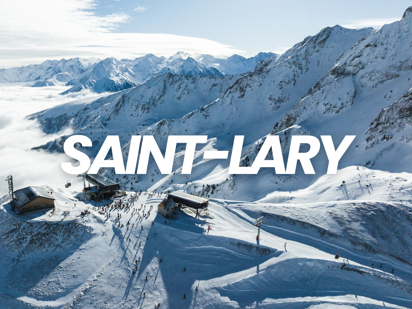 Station de ski en haute montagne avec des skieurs, entourée de montagnes enneigées, avec le texte "SAINT-ALARY" en gros caractères blancs.